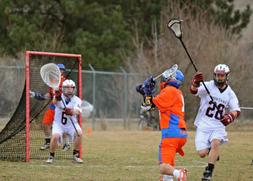 Rival teammates face off at the beginning of a lacrosse game, during the 2013 lacrosse season. After a faceoff is won, the team with the ball passes it until they are close enough to the opponent's goal to shoot. Meanwhile, defenders try to keep the offensive team from scoring. A shot that travels past the goalie and into the goal counts as one point. (Courtesy photo) 