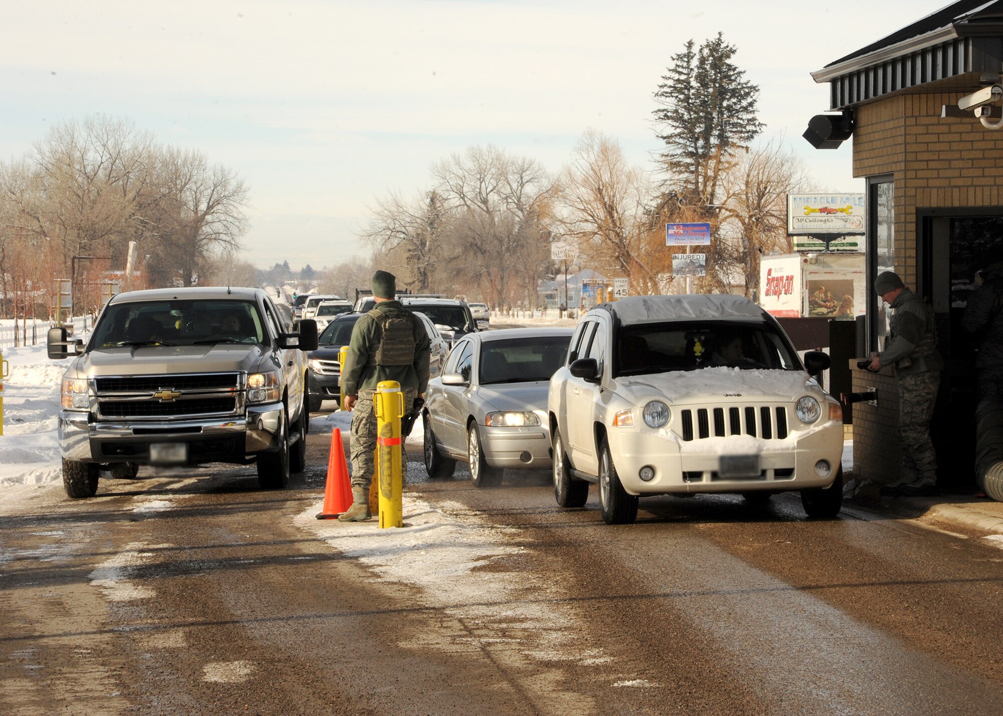 Two gate guards conduct ID checks at Malmstrom’s main gate Feb. 10. Gate guards are on duty 24 hours a day, seven days a week. (U.S. Air Force photo/Senior Airman Cortney Paxton)