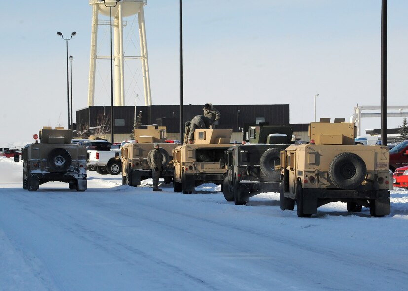 Security Forces members prepare Humvees for transportation to the missile complex in freezing temperatures Feb. 3. Having the proper cold-weather gear on while outside in the cold is important to avoid frostbite and hypothermia. (U.S. Air Force photo/Senior Airman Cortney Paxton)