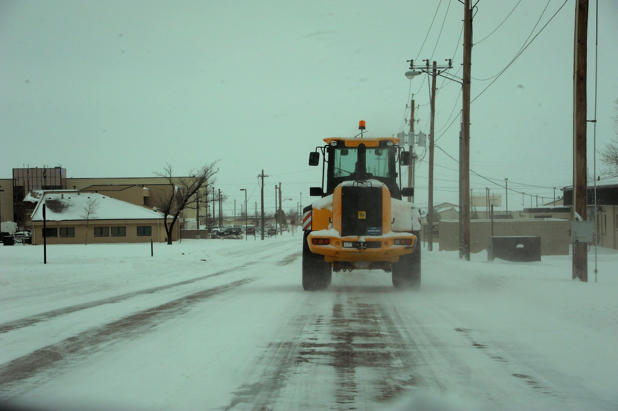 A snow plow clears snow from Flightline Drive on Malmstrom Air Force Base after a recent snowfall. Temperatures were in the negatives during the first week of February, making work outside riskier; Airmen across base and within the missile complex had to watch their exposure to the climate even more than usual. (U.S. Air Force photo/Senior Airman Cortney Paxton)