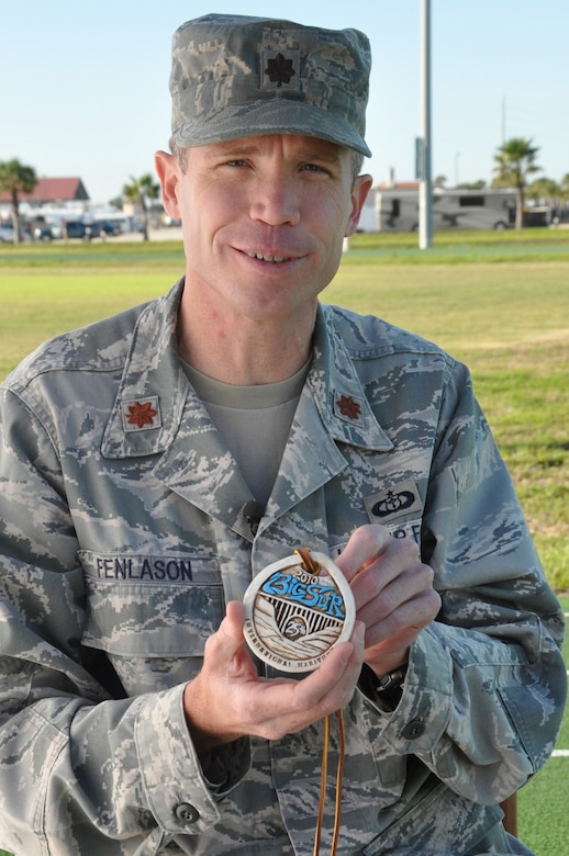 Maj. Joel Fenlason, 45th Space Wing deputy director of staff, holds up a medal he earned for running the Big Sur International Marathon in Calif. He started running marathons in 2005 when he was 31 years old. His goal was to complete 50 marathons by his 40th birthday. Now 40, he is preparing to run his 75th marathon Feb. 16. (U.S. Air Force Photo/Tech. Sgt. Erin Smith)