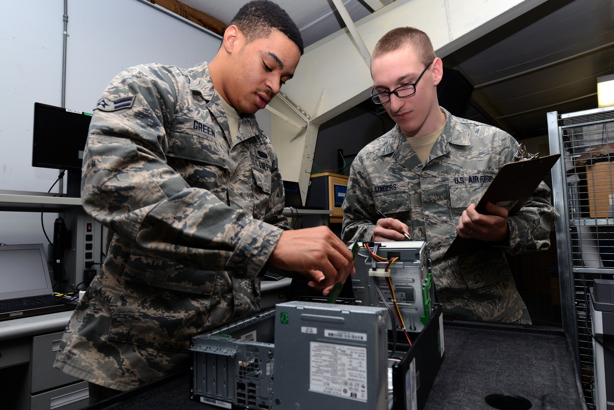 Staff Sgt. Luke Sandars (right) 22nd Communications Squadron quality assurance evaluator, reviews upgrade training tasks with Airman 1st Class Kevin Green (left) 22nd CS client systems technician, Feb. 13, 2014, at McConnell Air Force Base, Kan. Sanders was selected as the spotlight performer for the week of Feb. 7 through 7. He is part of a team that maintains the commander’s inspection program, among other programs. (U.S. Air Force photo/Airman 1st Class John Linzemeir)
