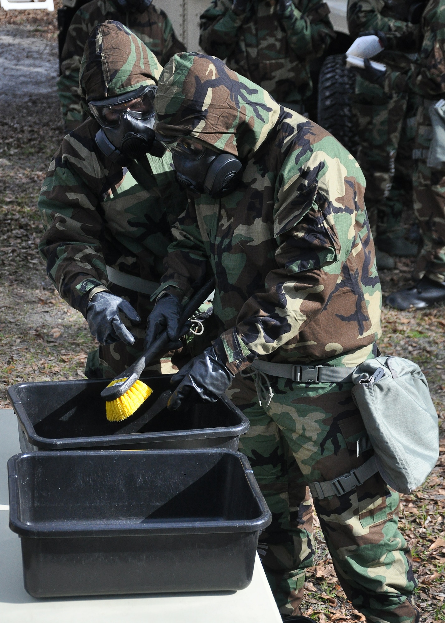 A group of Airmen perform a decontamination training scenario Feb. 13, at Heritage Park. More than 200 Airmen participated in a Mission-Oriented Protective Posture equipment exercise. (U.S Air Force photo by Airman 1st Class Solomon Cook)