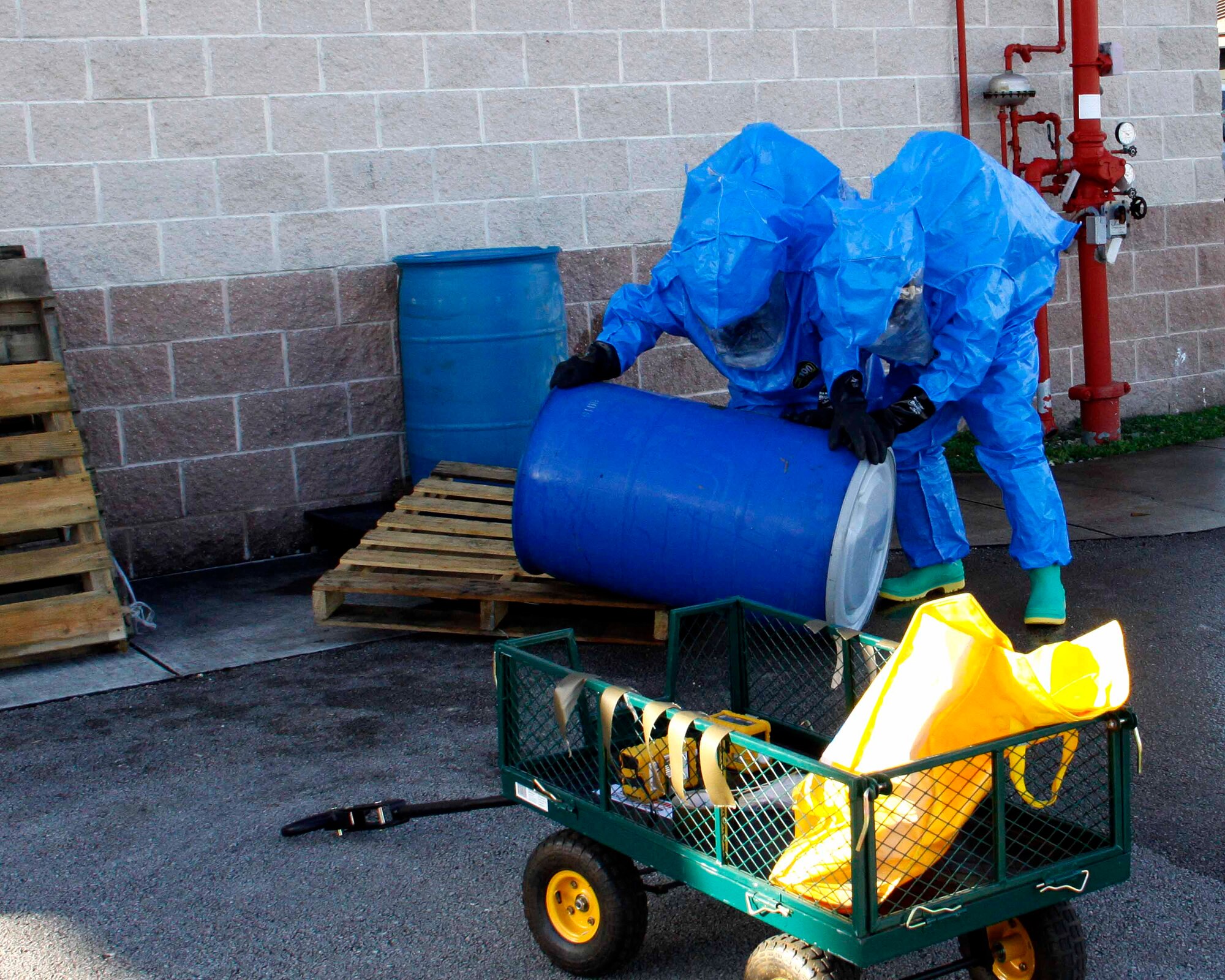 Senior Airman Juan Rodriguez and Senior Airman Anthony Ramirez, emergency management technicians with the 482nd Civil Engineering Squadron Emergency Management flight at Homestead Air Reserve Base, Fla., work together to re-orient a leaking barrel during their annual hazardous material exercise at Homestead ARB, Feb. 8. (U.S. Air Force photo by/Senior Airman Jaimi L. Upthegrove)