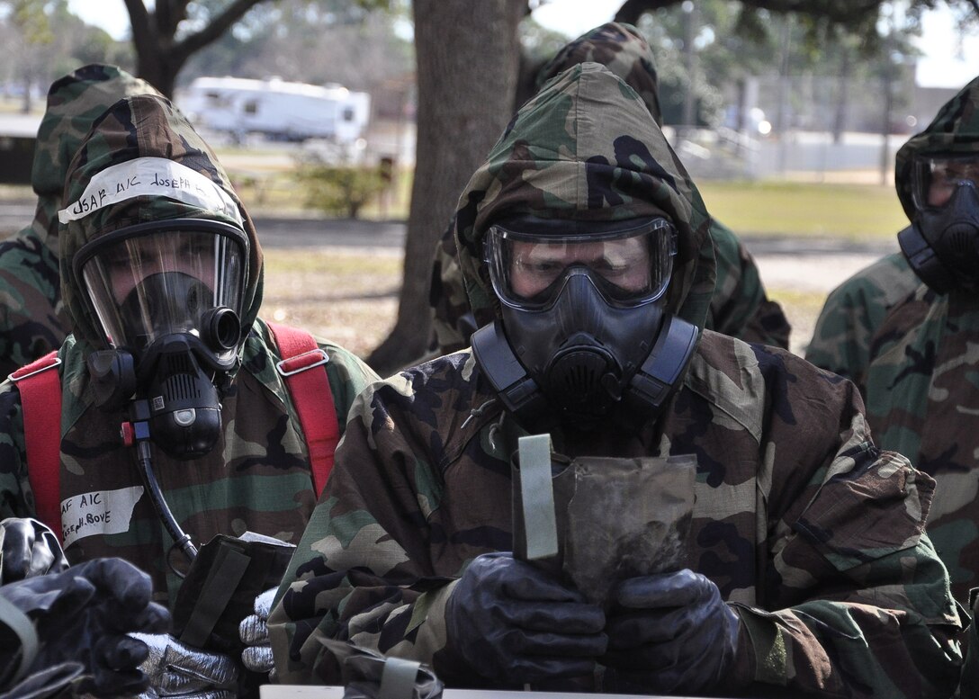 A group of Airmen prepare for a vehicle decontamination training scenario Feb. 13, at Heritage Park. They wear Mission-Oriented Protective Posture equipment as part of a Combat Airman Skills Evaluation exercise. (U.S Air Force photo by Airman 1st Class Solomon Cook)