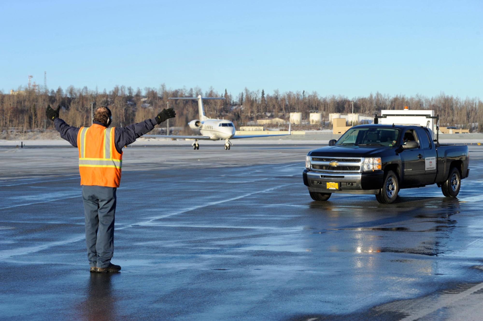 Gary Howard, left, and Novell Howard, members of Transient Alert, direct an aircraft carrying Air Force Lt. Gen. Stanley Clarke on Joint Base Elmendorf-Richardson, Alaska, Jan. 29, 2014. TA, a part of the 3rd Maintenance Squadron, provides support for any aircraft transiting through JBER. Gary Howard is a TA aircraft servicer and a native of Summersburg, N.H. Novell Howard is the project manager for TA and is a native of Los Angeles. Clarke is the director of the Air National Guard. (U.S. Air Force photo/Staff Sgt. Robert Barnett)