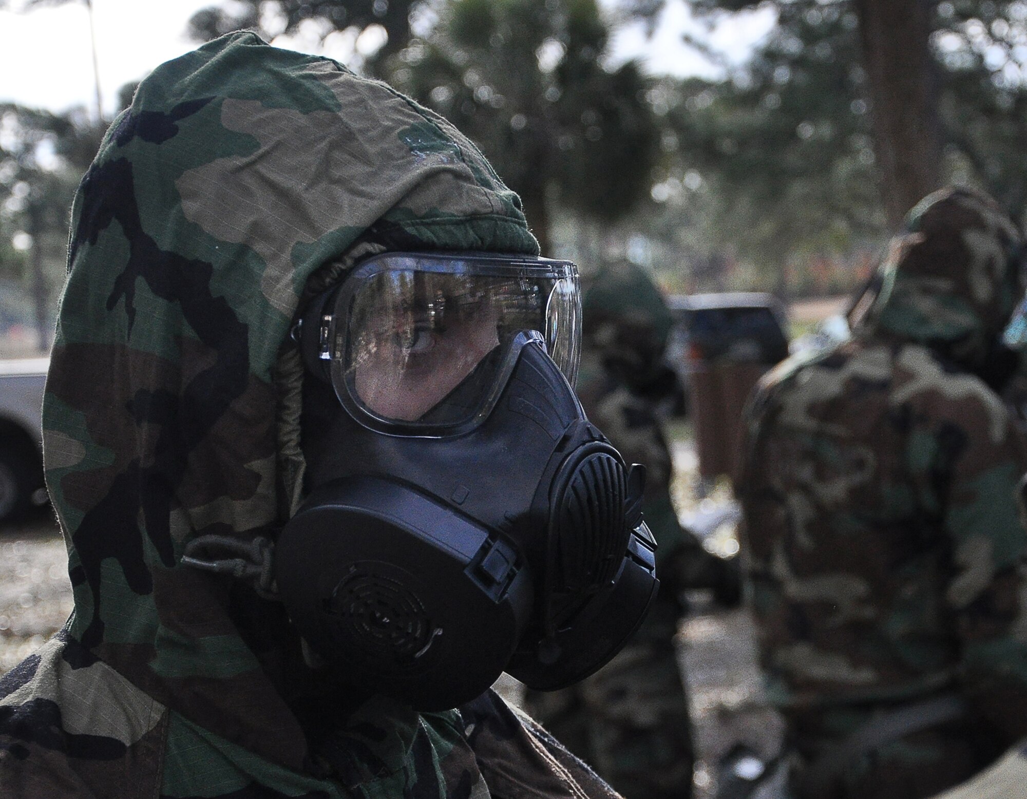 A Tyndall Airman dawns Mission-Oriented Protective Posture during a decontamination training scenario Feb. 13, at Heritage Park. After they suit up in their MOPP gear, the Airmen proceeded through four stations to hone the skills needed during a deployment or chemical attack.. (U.S Air Force photo by Airman 1st Class Solomon Cook)