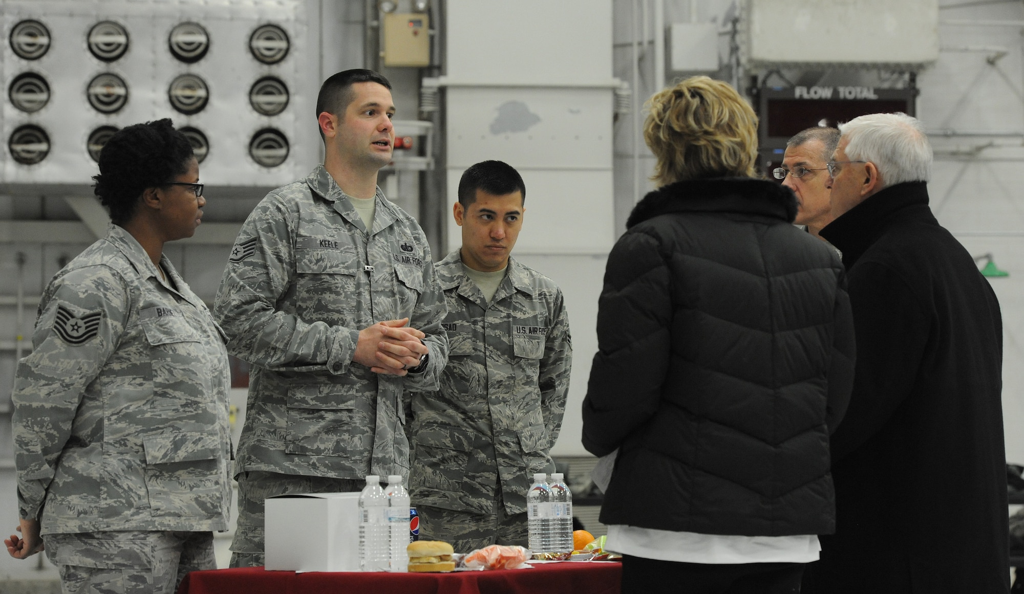 Staff Sgt. Travis Keele, 509th Force Support Squadron Ozark Inn store room manager, briefs Hennessy Team evaluators on the in-flight meal experience on the flightline at Whiteman Air Force Base, Mo., Feb. 5, 2014. During the in-flight experience, evaluators were briefed on the various types of foods that pilots can bring with them during flights. (U.S. Air Force photo by Staff Sgt. Nick Wilson/Released)