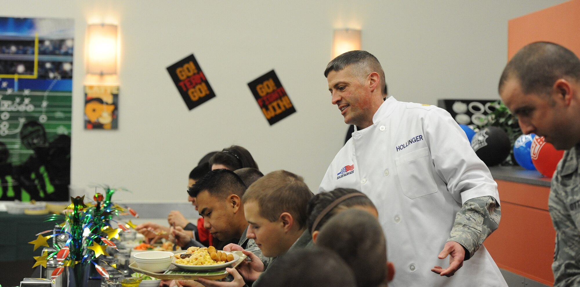Maj. Chip Hollinger, 509th Force Support Squadron commander, serves a birthday 
meal to an Airman during a Hennessy Team inspection at the Ozark Inn dining facility at Whiteman Air Force Base, Mo. Feb. 5, 2014. The Hennessy Team also visited the Touch-and-Go flight kitchen and received a tour of a B-2 Spirit as part of their two-day visit to Whiteman (U.S. Air Force photo by Staff Sgt. Nick Wilson/Released)