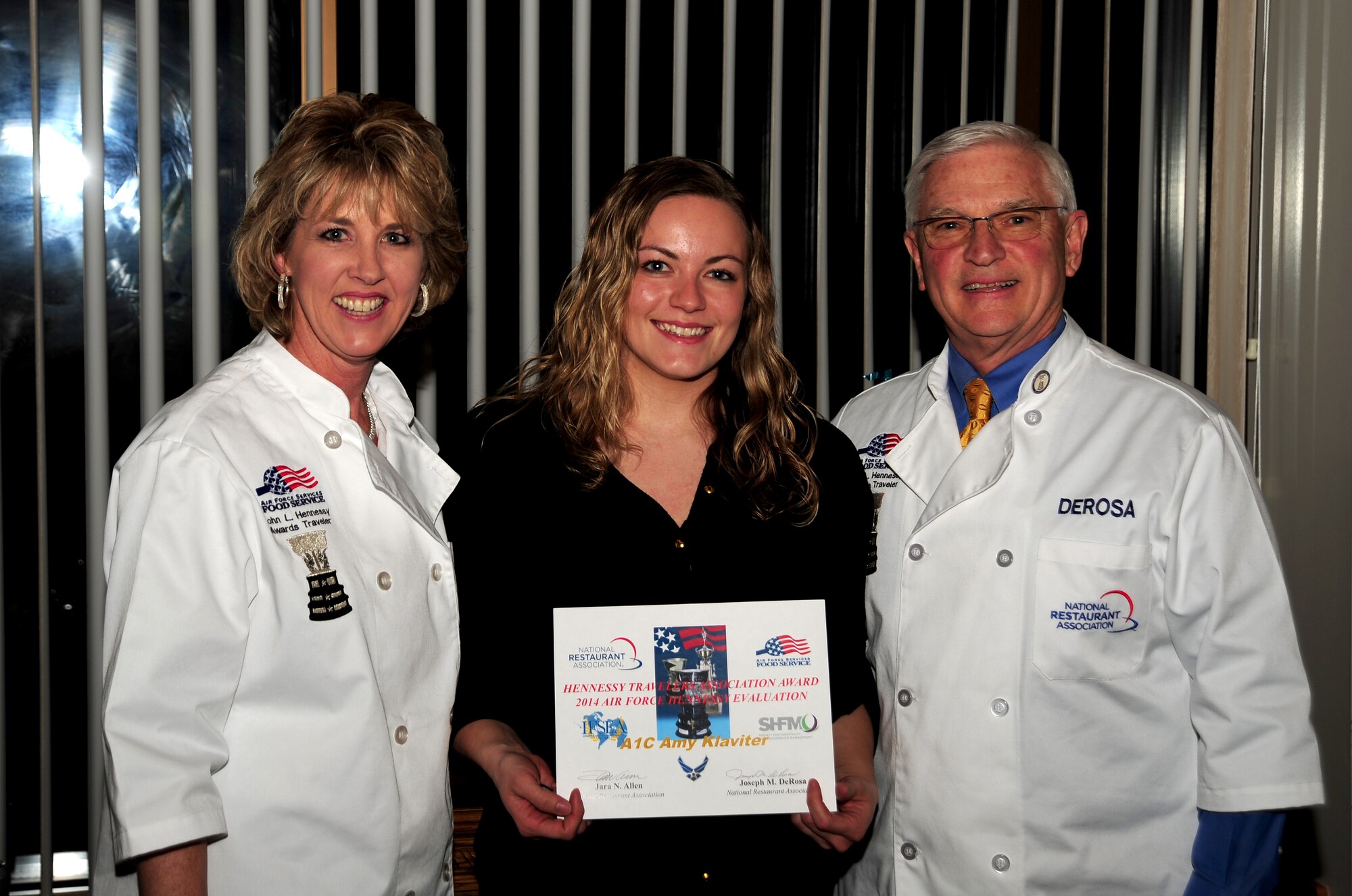 Airman 1st Class Amy Klaviter, 509th Force Support Squadron food service specialist, is presented with the Hennessy Traveler’s Association Award of Excellence by Hennesy Team evaluators, Jara Allen and Joe DeRossa, at the Royal Oaks Golf Course in Knob Noster, Mo., Feb. 6, 2014. Each year the Hennessy Team chooses one enlisted member from a dining facility they visit to participate in a class at the Culinary Arts Institute of America in Greystone, Calif. Klaviter received the award because she was recognized as a superior performer during the inspection. (U.S. Air Force photo by Staff Sgt. Nick Wilson/Released)