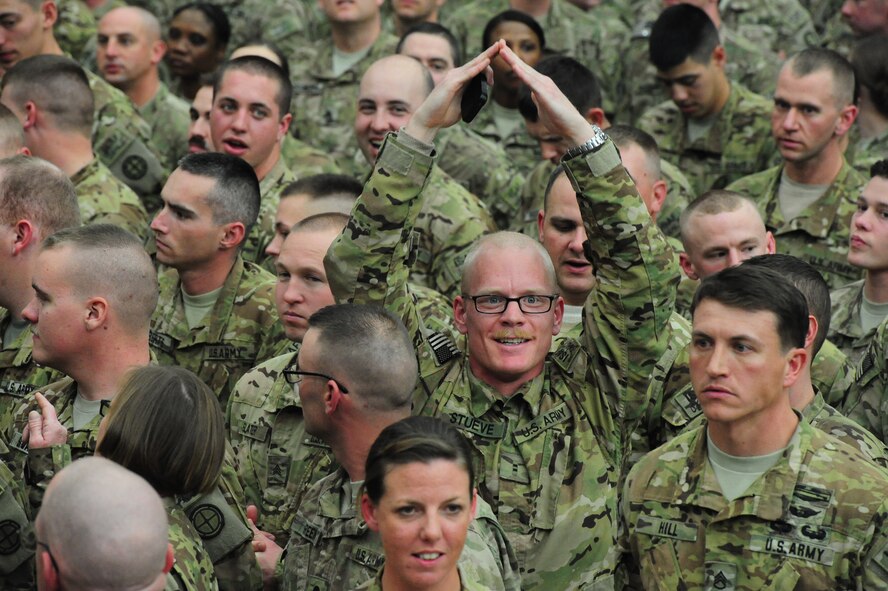 U.S. Army Chief Warrant Officer II Patrick Stueve, 1-135th Attack Reconnaissance Battalion pilot, signals to his family during a ceremony in honor of their return from a deployment at the University of Central Missouri  in Warrensburg, Mo., Feb. 9, 2014. More than 300 soldiers deployed to Afghanistan on a year-long deployment in support of Operation Enduring Freedom. (U.S. Air Force photo by Staff Sgt. Nick Wilson/Released)