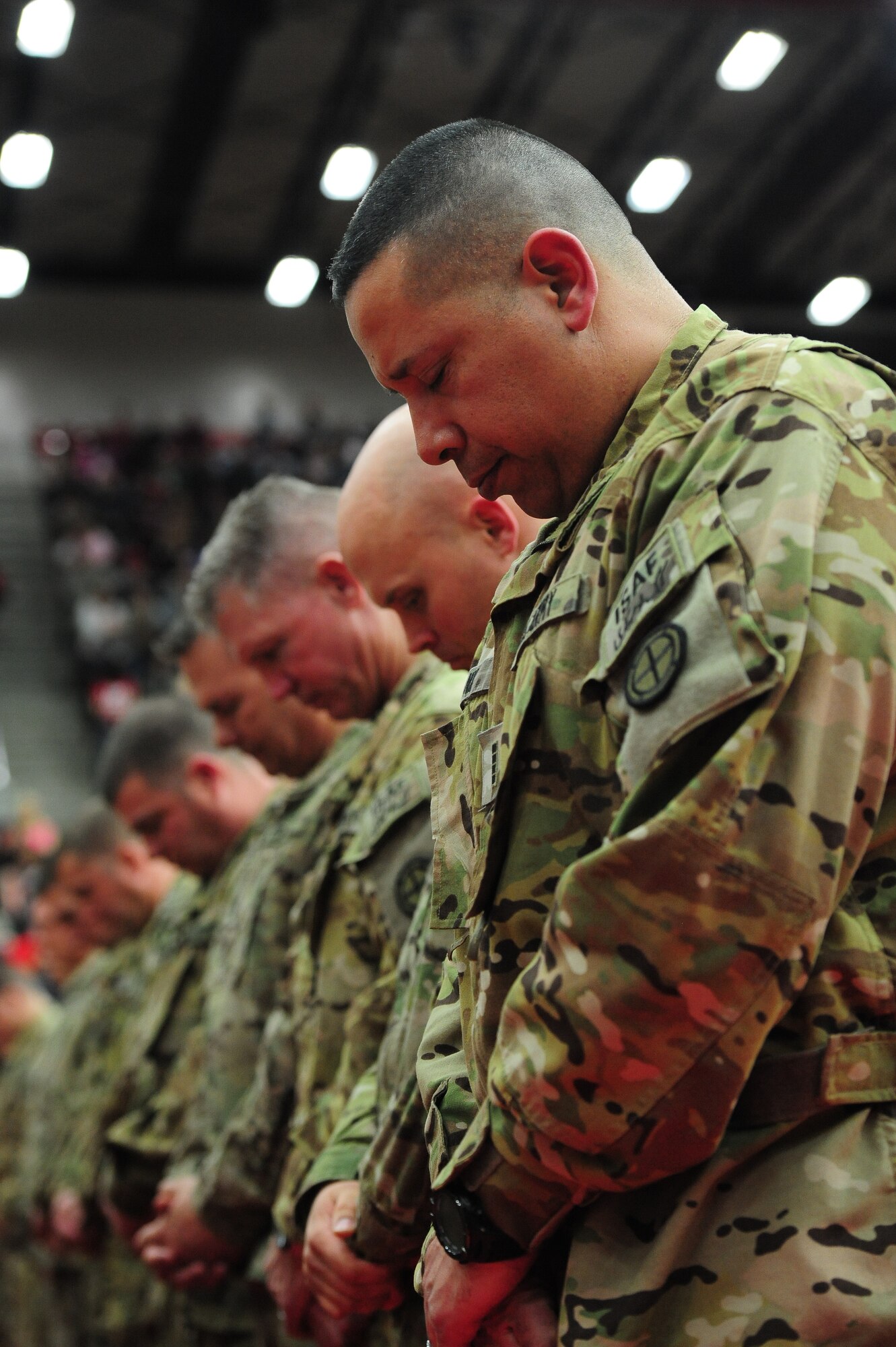 U.S. Army Soldiers from the 1-135th Attack Reconnaissance Battalion bow their heads during the unit's welcome-home ceremony at the University of Central Missouri in Warrensburg, Mo., Feb. 9, 2014. The unit, which flies the AH-64D Apache helicopter, 
deployed more than 300 soldiers to Afghanistan to aid in Operation Enduring Freedom. (U.S. Air Force photo by Staff Sgt. Nick Wilson/Released)