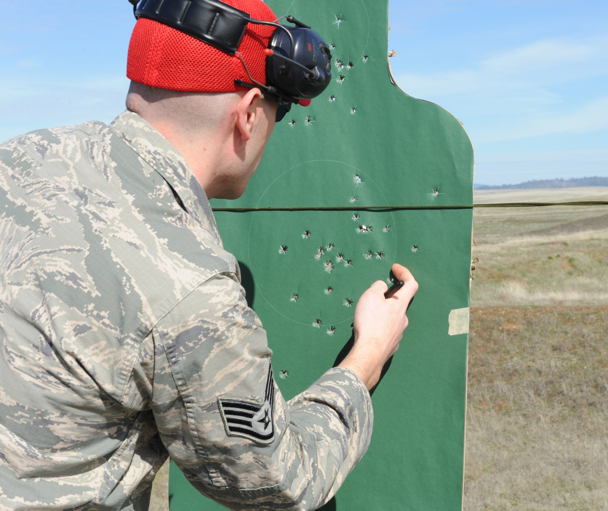 A 9th Security Forces Squadron combat arms instructor, grades a target during a weapons qualification course at Beale Air Force Base, Calif., Feb. 11, 2014. Students with high marksmanship scores in the M-16, M-4, or M-9 courses can be awarded the small arms marksmanship ribbon. (U.S. Air Force photo by Staff Sgt. Robert M. Trujillo/Released)