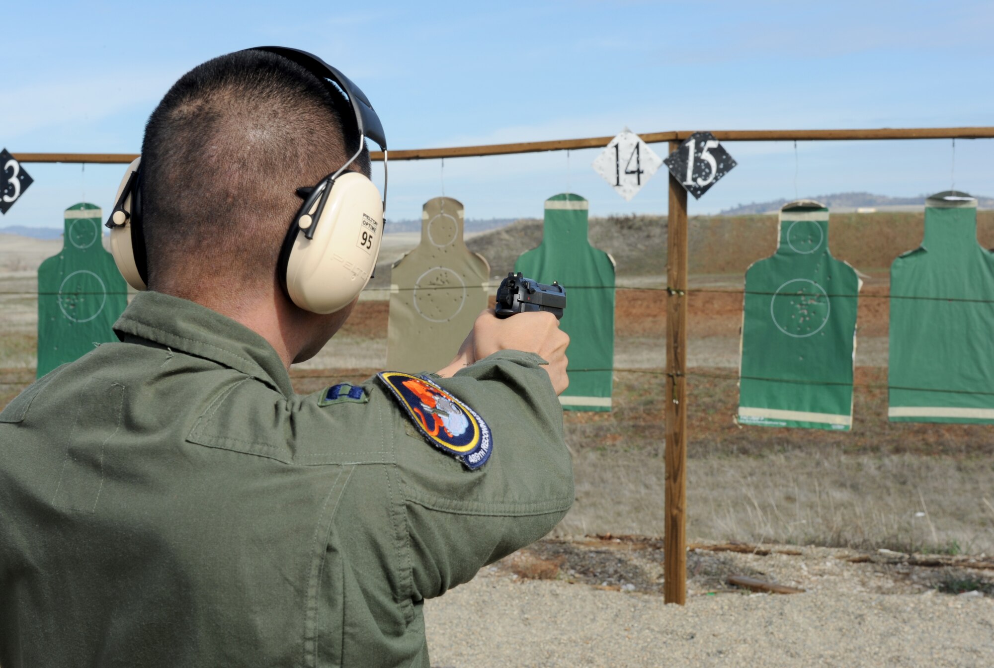 An Airman fires the M-9 pistol during a weapons qualification course at Beale Air Force Base, Calif., Feb. 11, 2014. Students with high marksmanship scores in the M-16, M-4, or M-9 courses can be awarded the small arms marksmanship ribbon.  (U.S. Air Force photo by Staff Sgt. Robert M. Trujillo/Released)