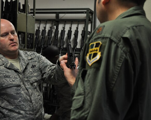Master Sgt. Chad Knox, 9th Security Forces Squadron NCO in charge of the combat arms section, issues an M-9 pistol at Beale Air Force Base, Calif., Feb. 11, 2014. The M-9 is the primary pistol of the U.S. Air Force. (U.S. Air Force photo by Staff Sgt. Robert M. Trujillo/Released)