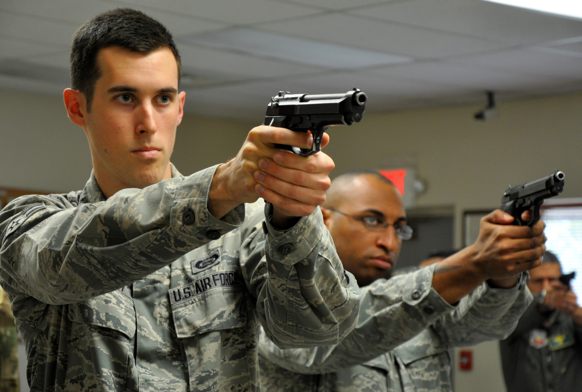 Airmen practice aiming the M-9 pistol during a weapons qualification course at Beale Air Force Base, Calif., Feb. 11, 2014. The course is taught by the 9th Security Forces Squadron combat arms section. (U.S. Air Force photo by Staff Sgt. Robert M. Trujillo/Released)  