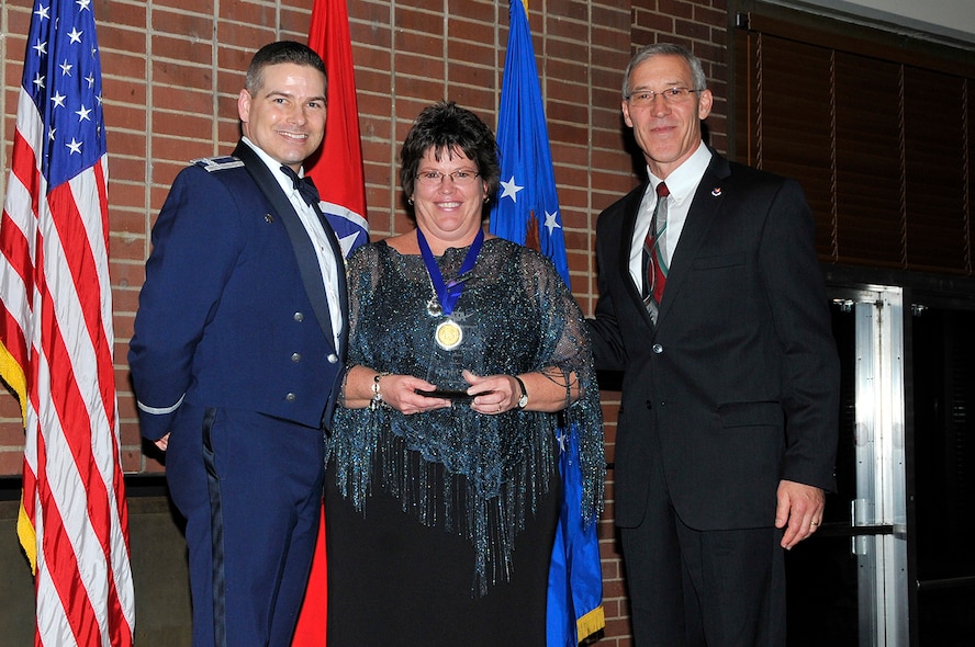 Cheryl Posey (center) receives the Annual ATA Internal Customer Service Excellence award from AEDC Commander Col. Raymond Toth (left) and ATA Deputy General Manager Phil Stich at the AEDC Annual Award Banquet.