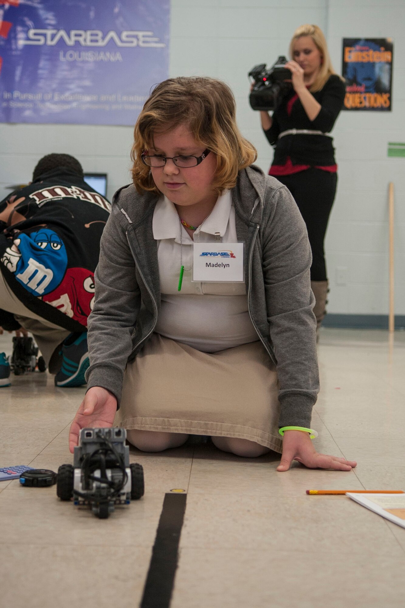 Wendi Redman, a reporter with KTBS Channel 3 in Shreveport, La., records students participating in a “Robotics Challenge” at STARBASE Louisiana located on Barksdale Air Force Base, La., Feb. 13, 2014. The students programmed a robot to travel the 1,300 meters from the Lincoln Memorial to the Washington Monument, using a scale of 1:260. STARBASE presents an exciting 25-hour hands-on minds-on Science, Technology, Engineering, and Mathematics (STEM) curriculum to area 5th grade students and their teachers. (U.S. Air Force photo by Master Sgt. Jeff Walston/Released) 