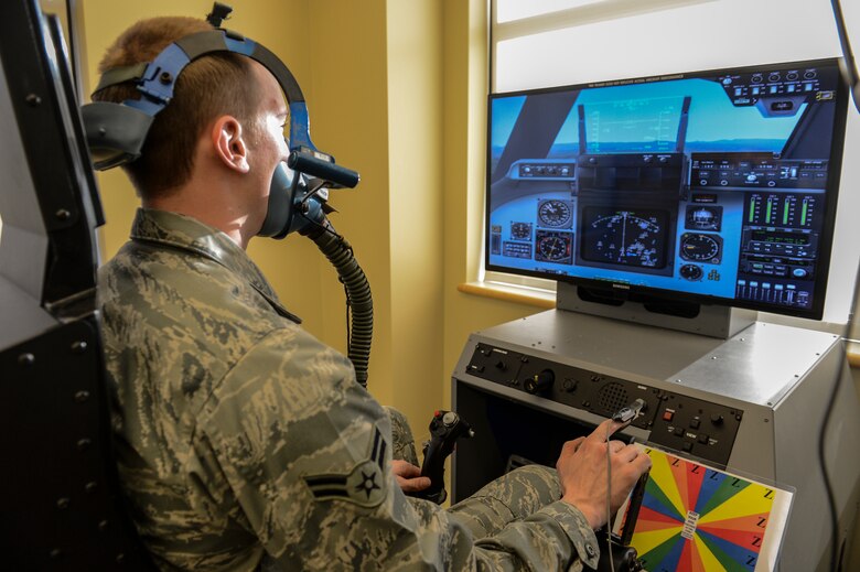 Airman 1st Class Erich Held, 62nd Medical Squadron optometry technician demonstrates how pilots would use the Reduced Oxygen Breathing Device at the McChord Clinic, Feb. 5, 2014, Joint Base Lewis-McChord, Wash. The ROBD is combined with a flight simulator that can change its heads up display to match the specific aircraft the training pilot flies. (U.S. Air Force photo/Tech. Sgt. Sean Tobin)