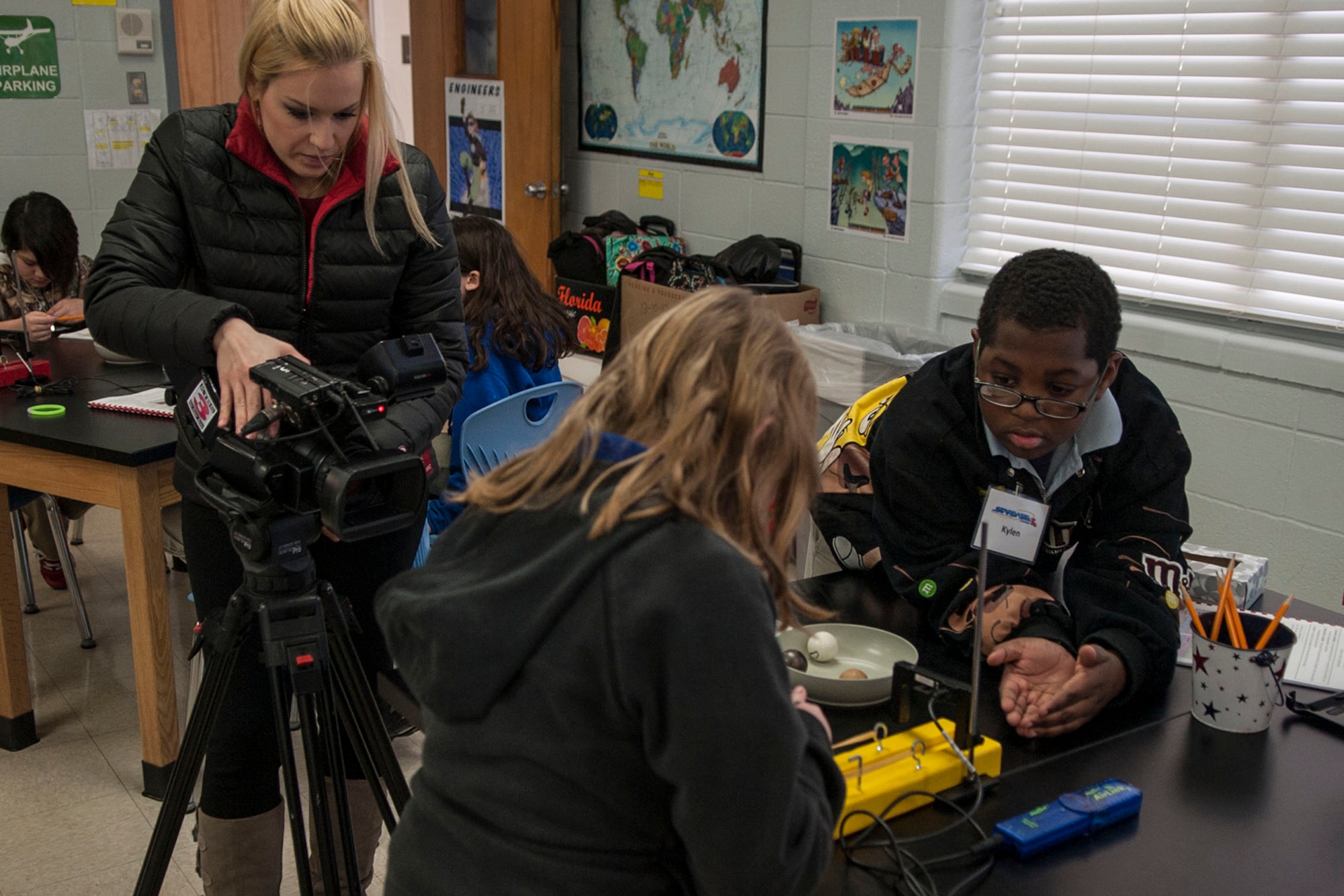 Wendi Redman, a reporter with KTBS Channel 3 in Shreveport, La., records students studying “Newton’s 2nd Law of Motion” at STARBASE Louisiana located on Barksdale Air Force Base, La., Feb. 13, 2014. STARBASE presents an exciting 25-hour hands-on minds-on Science, Technology, Engineering, and Mathematics (STEM) curriculum to area 5th grade students and their teachers. (U.S. Air Force photo by Master Sgt. Jeff Walston/Released) 