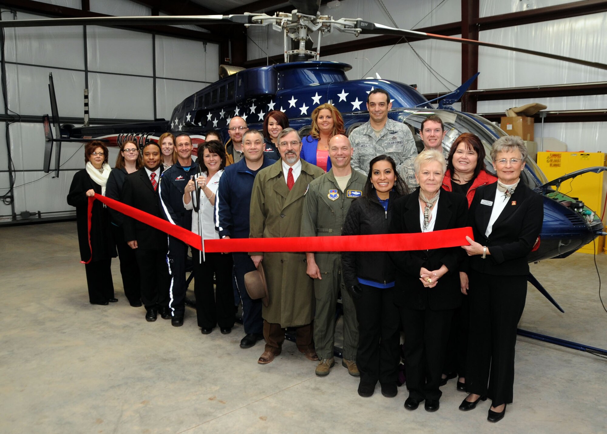 ALTUS, Okla. – Local community members and U.S. Air Force members pose for a photo during a ribbon cutting ceremony in the Air Evac Lifeteam hangar at the Altus Quartz Mountain Regional Airport, Feb. 11, 2014. The air evacuation team coordinates with the Altus Air Force Base control tower and radar approach control center during emergencies so the base can maintain a clear airspace, allowing the air ambulance to fly over the base. (U.S. Air Force photo by Senior Airman Franklin R. Ramos/Released)
