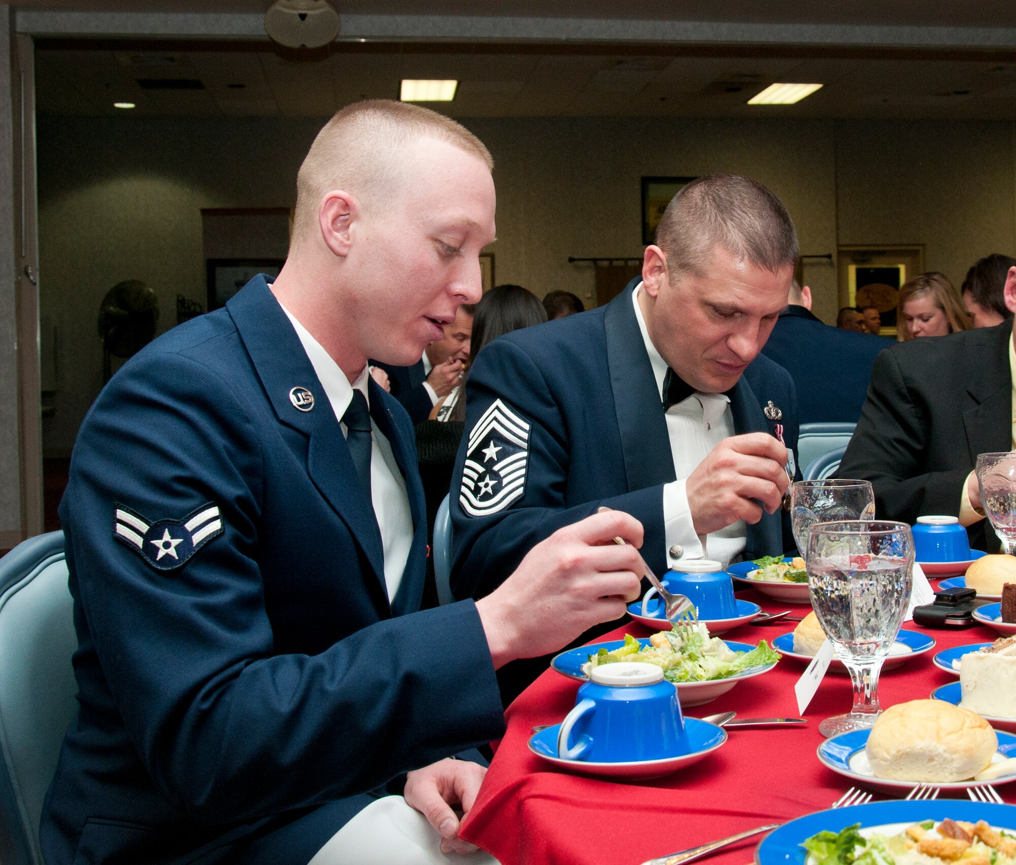 Airman 1st Class Troy Engholm, 90th Logistics Readiness Squadron traffic management technician, chats with Chief Master Sgt. Michael Garrou, 90th Missile Wing command chief, during the Airman Leadership School 14-C graduation ceremony in the Trail’s End Club Feb. 12, 2013. Engholm is the latest Airman to take part in Garrou’s Shadow Program that allows Garrou to mentor junior enlisted Airman and give the Airmen a chance to see the daily life of a senior enlisted leader. A new shadow spends the day with Garrou the second Wednesday of each month — a time chosen partly because it typically coincides with ALS graduations and gives the shadows a chance to see an ALS graduation before it is their time to attend ALS. (U.S. Air Force photo by Airman 1st Class Jason Wiese)