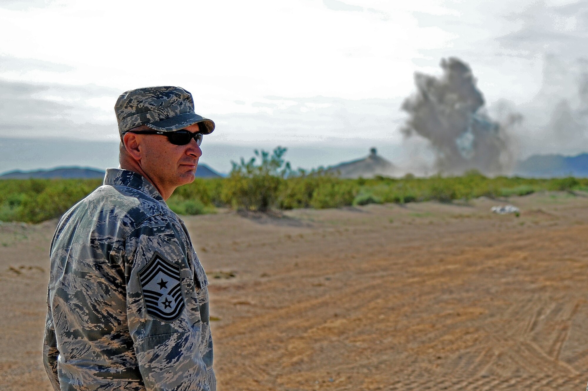 Chief Master Sgt. John Mazza, 56th Fighter Wing command chief, watches the 56th CES Explosive Ordnance Disposal team explode undetonated ordnance at the high explosives hill at the Barry M. Goldwater Range. The EOD unit clears the range for maintenance to replace the targets for pilot training. (U.S. Air Force photo/Airman 1st Class Pedro Mota)