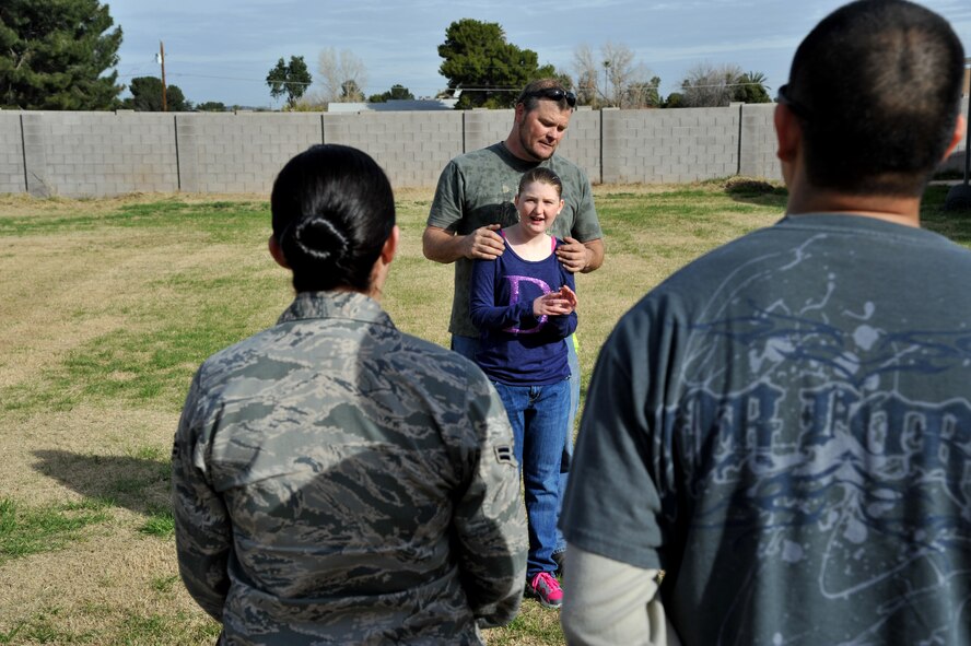 Solomon Galyon, a member of the Society for Creative Anachronisms, introduces his daughter Dierdre, 13, to Luke Air Force Base Airmen who helped set up the Heroes of Silent Angels event. Dierdre is afflicted with Rett Syndrome, a form of autism that renders those who have it unable to speak, often unable to walk or care for themselves, and can cause seizures. (U.S. Air Force photo/Senior Airman Jason Colbert)