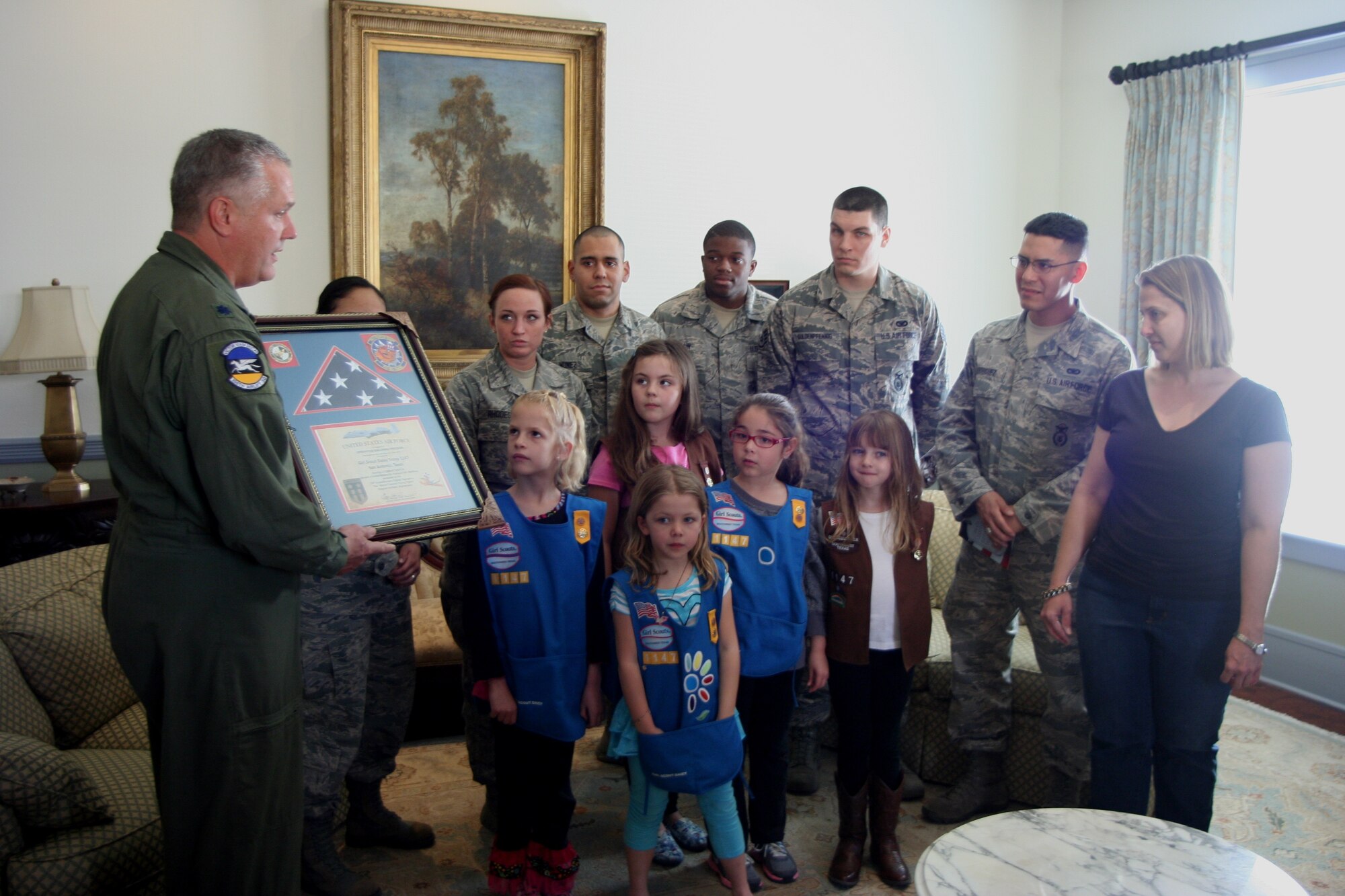 Col. Jimmie Brooks, 356th Airlift Squadron, commander (433rd Airlift Wing) presents an American Flag to Troop Leader Christine Wilson of the Girl Scouts of Southwest Texas, Troop 1147 for their support while deployed in support of Operation Enduring Freedom, Feb. 9, 2014. The flag was flown over Afghanistan, while the Airmen were deployed in support of Operation Enduring Freedom. The presentation was held at the Sally Cheever Girl Scout Leadership Center in San Antonio.