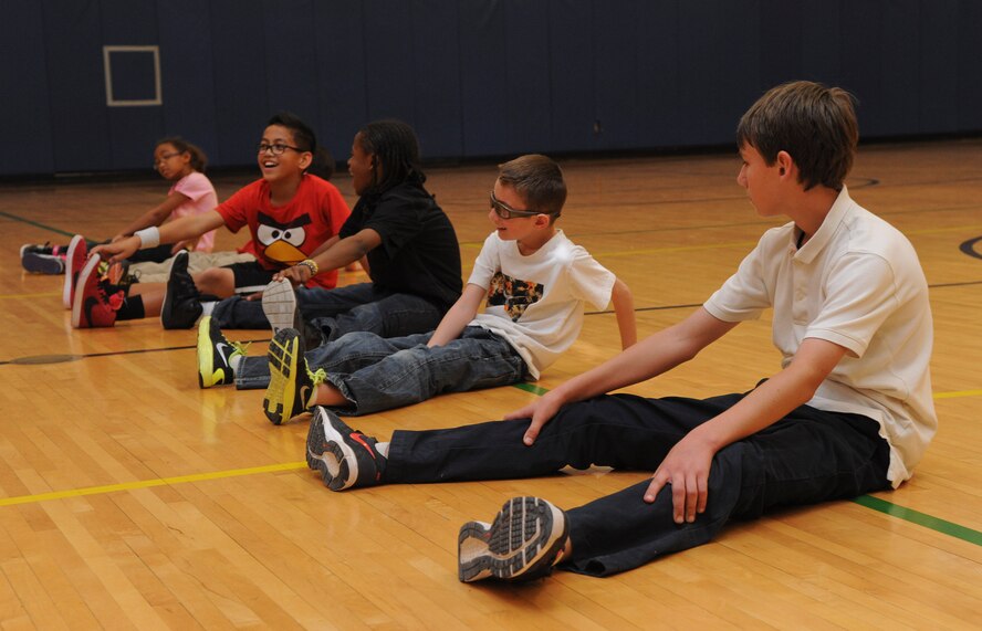 Children perform stretches after a series of exercises Monday during the Kids Boot Camp Challenge at the 56th Force Support Squadron Youth Center. The Boot Camp Challenge is a series of activities conducted over a six-to-eight-week period that encourage physical activity through a variety of enjoyable and competitive exercises. (U.S. Air Force photo/Staff Sgt. Darlene Seltmann)
