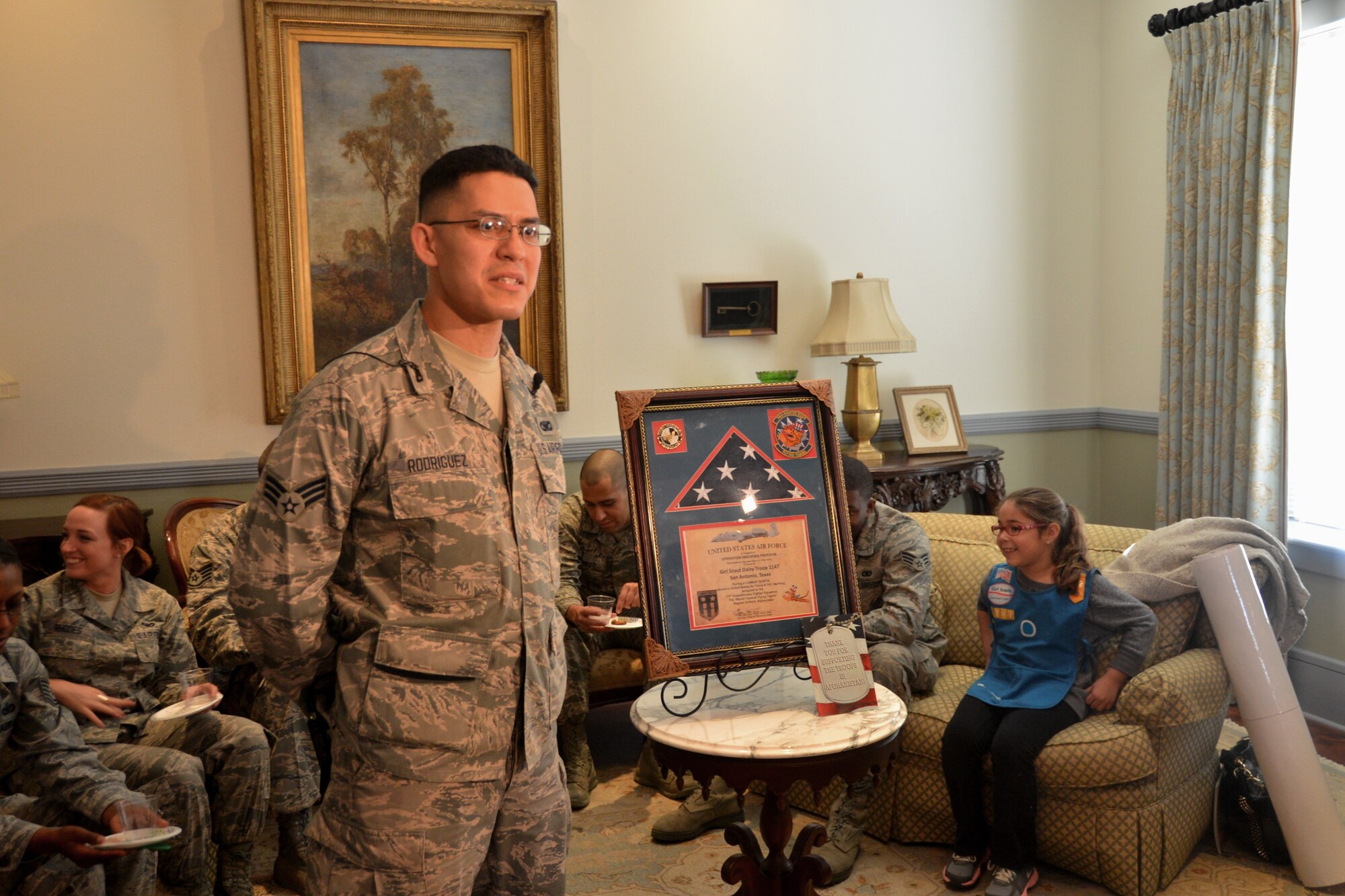 SrA Pedro Rodriguez, 433rd Security Forces Squadron, security forces specialist, spearheaded the campaign to thank the Girl Scouts of Southwest Texas, Troop 1147 for mailing close to 50 boxes of Girl Scout cookies, cards and toiletries while they were deployed to Bagram Air Field, Afghanistan. He had an American Flag flown over Afghanistan as a form of appreciation for their support while deployed in support of Operation Enduring Freedom. He and the rest of the deployed Airmen, presented the flag to them at the Sally Cheever Girl Scout Leadership Center in San Antonio Feb. 9, 2014.