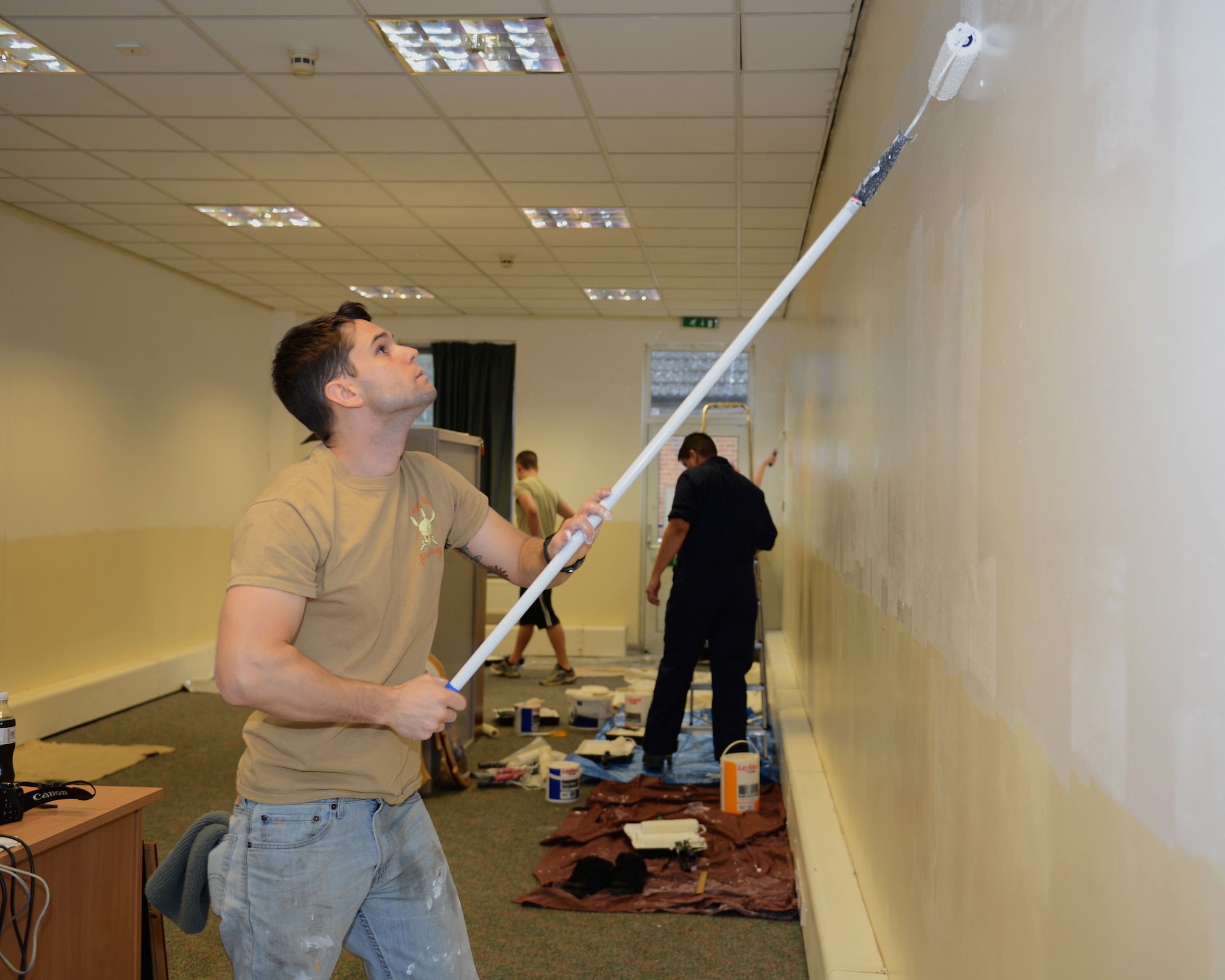 U.S. Air Force Staff Sgt. Filipi Wiederkehr, 100th Logistics Readiness Squadron NCO in charge of packing and crating from Phoenix, a the wall in the 100th Air Refueling Wing, Flight Room Feb. 14, 2014, in Mathies Airman Leadership School on RAF Feltwell, England. Wiederkehr, along with several volunteers, worked with the Team Mildenhall Top 3 to renovate the classroom and inspire future students. The Top 3 also donated several historic memorabilia items for display in the room including artwork, tail flashes and a Square D emblem. (U.S. Air Force photo by Airman 1st Class Preston Webb/Released)