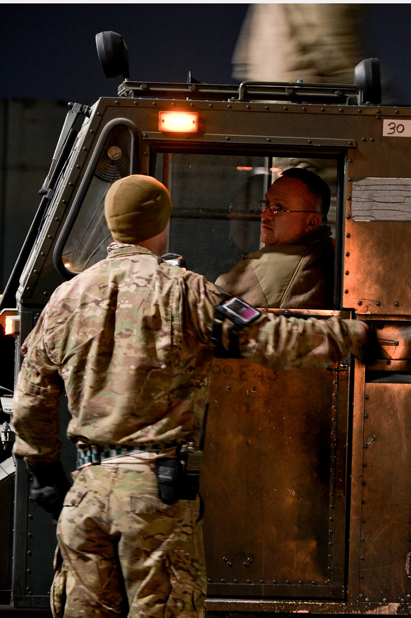 U.S. Air Force Airmen assigned to the 455th Expeditionary Aerial Port Squadron discuss moving a Tunner 60K loader at Bagram Airfield, Afghanistan, Feb. 13, 2014. Members of the 455th EAPS used the Tunner 60K loader to down-load a C-17 Globemaster III. (U.S. Air Force photo by Senior Airman Kayla Newman/Released)