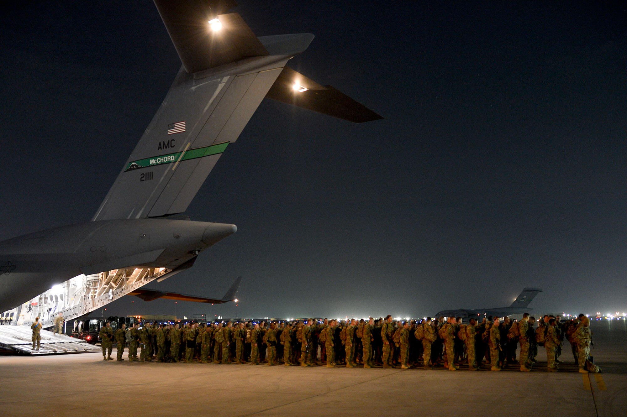 Service members file out of a C-17 Globemaster III at Bagram Airfield, Afghanistan, Feb. 13, 2014. Several cargo pallets and passengers were downloaded from a C-17, deployed from Joint Base Lewis-McChord, Wash. (U.S. Air Force photo by Senior Airman Kayla Newman/Released)