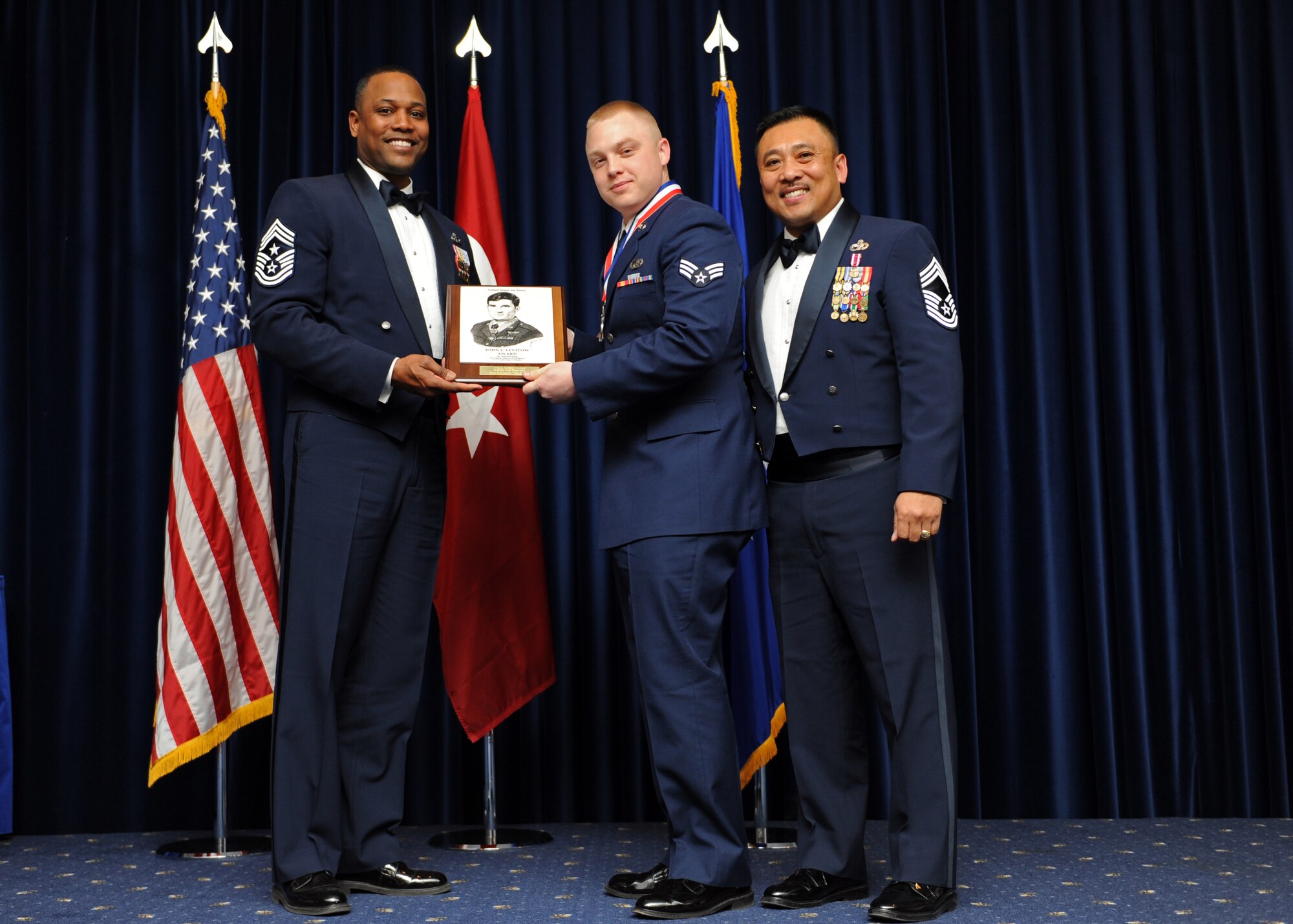 Senior Airmen Robert Waggoner, American Forces Network - Incirlik, receives the John L. Levitow Award from Chief Master Sgt. Anthony Johnson, 39th Air Base Wing command chief, during the Airmen Leadership School graduation Feb. 13, 2014, at Incirlik Air Base, Turkey. The Levitow Award is the highest achievement for enlisted Airmen enrolled in Airmen Leadership School. There are four levels of Professional Military Education: ALS, NCO Academy, Air Force Senior NCO Academy and Chief Master Sergeant Leadership Course. (U.S. Air Force photo by Senior Airman Chase Hedrick/Released)