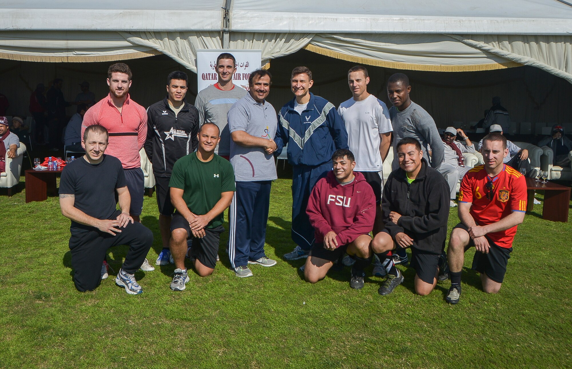 Service members pose with Maj. Gen. Mubarak Mohammed Al-Khayarin, Qatar Emiri air force commander, during Qatar National Sports Day at Al Udeid Air Base, Qatar, Feb. 11, 2014. For the first time more than 100 Airmen, Sailors, Soldiers, Marines and civilians were invited to participate in the event to play basketball, soccer and volleyball with their host nation counter parts. The Qatar National Sports Day is an initiative adopted in 2011 by the current Emir, Sheikh Tamim bin Hamad Al Thani, to further embed sporting values into the nation's culture and inspire people to be healthy and engage in physical activities. (U.S. Air Force photo/Senior Airman Jared Trimarchi) 