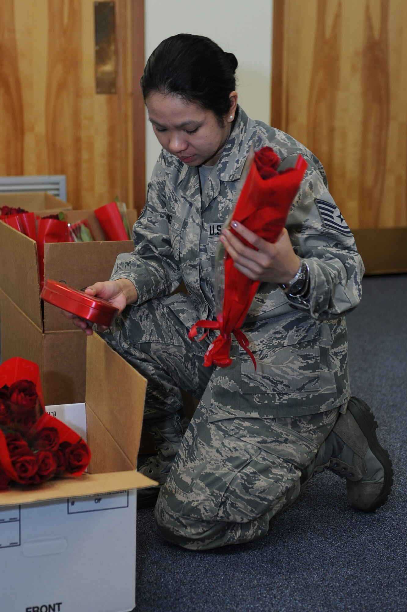 U.S. Air Force Tech. Sgt. Rosemarie Ching, 18th Civil Engineering Squadron customer service representative, sorts boxes of candy and bunches of flowers into boxes to be delivered on Kadena Air Base, Japan, Feb. 14, 2014.  The Valentine’s Day gift sets were sent out as a Kadena Top Three fundraiser, which is a professional organization interested in giving back to the community through professional development and community service. (U.S. Air Force photo by Airman 1st Class Zade C. Vadnais) 