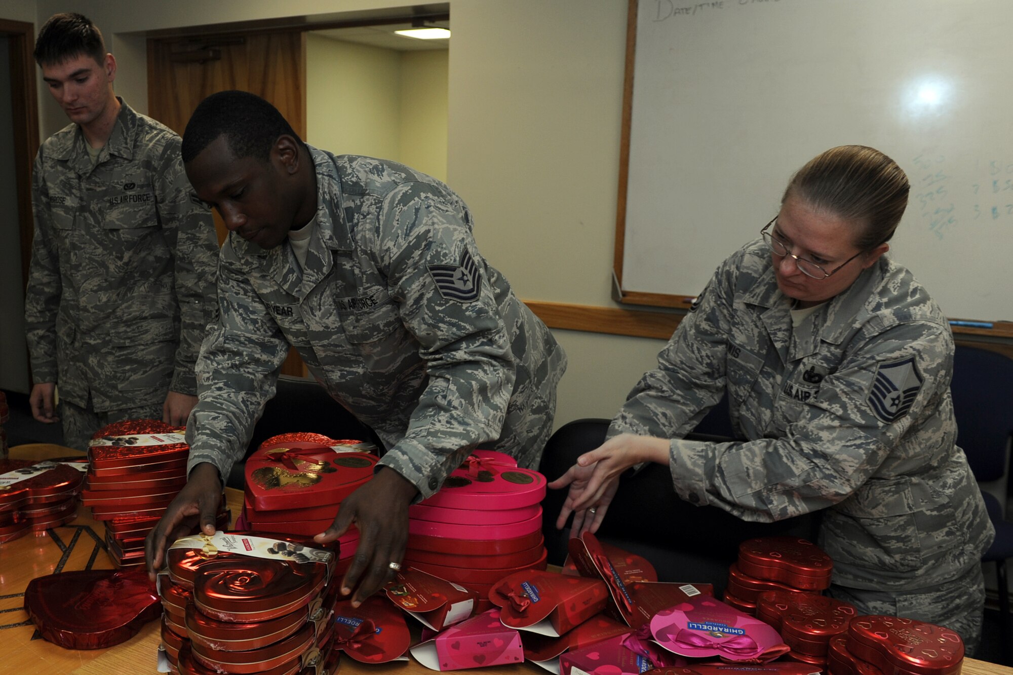 U.S. Air Force Airman 1st Class Brandon Ambrose, 18th Civil Engineering Squadron electrical journeyman, Tech. Sgt. Benjamin Puryear, 18th Communications Squadron NCO in charge of plans and implementation, and Master Sgt. Amber Lewis, 18th Security Forces Squadron Bravo flight chief, sort boxes of chocolate to be delivered on Kadena Air Base, Japan, Feb. 14, 2014.  The chocolates were sent, along with roses and personalized notes, as part of a Kadena Top Three Valentine’s Day fundraiser. (U.S. Air Force photo by Airman 1st Class Zade C. Vadnais)