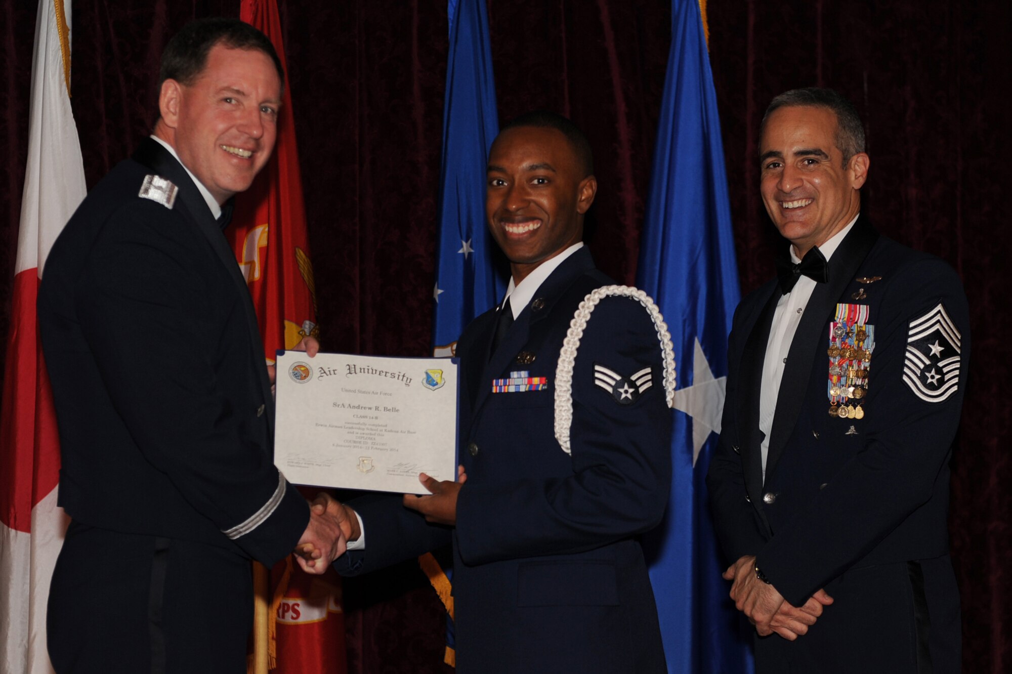 U.S. Air Force Senior Airman Andrew Belle, 353rd Special Operations Support Squadron cyber surety technician, accepts his Airman Leadership School diploma during the graduation ceremony for ALS Class 14-B on Kadena Air Base, Japan, Feb. 12, 2014.  Belle was also the recipient of the John L. Levitow Award, which is presented to the student who earns the highest average score on evaluations and most embodies the Air Force core values. (U.S. Air Force photo by Airman 1st Class Zade C. Vadnais)