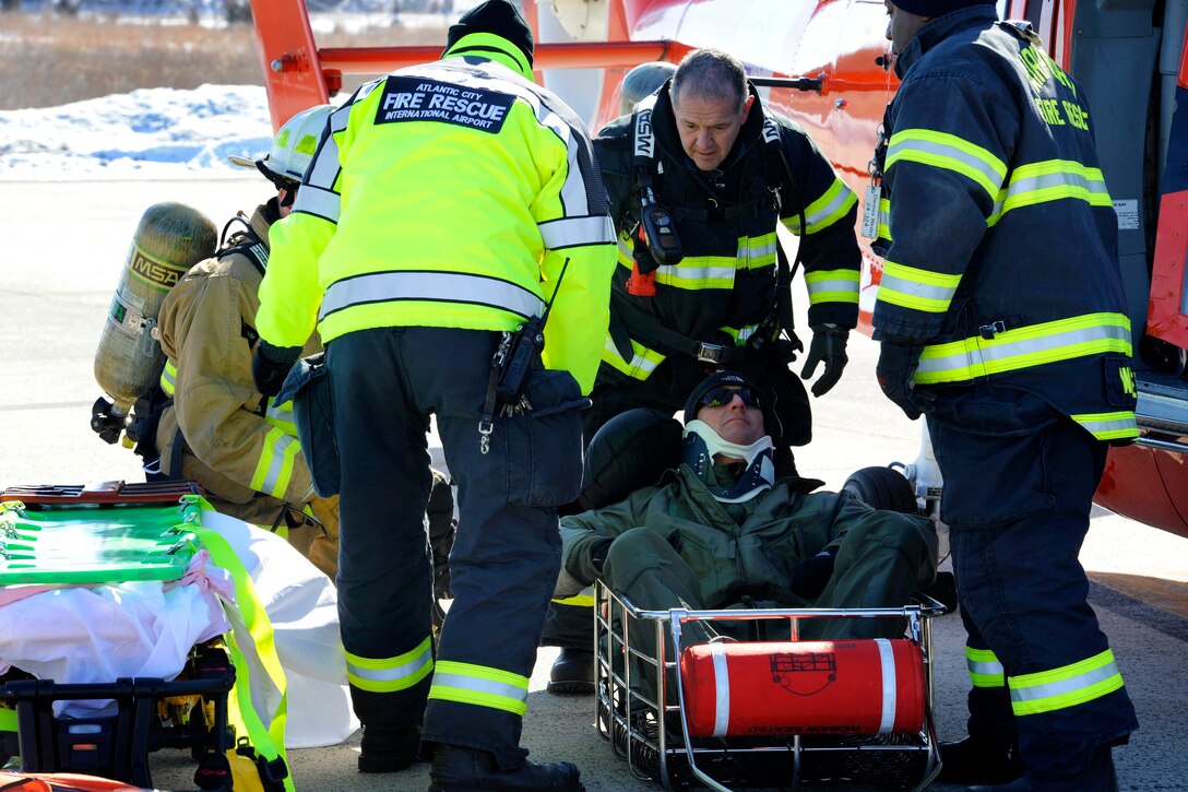 Emergency response personnel assist Air Force Maj. Jared Mandella ...