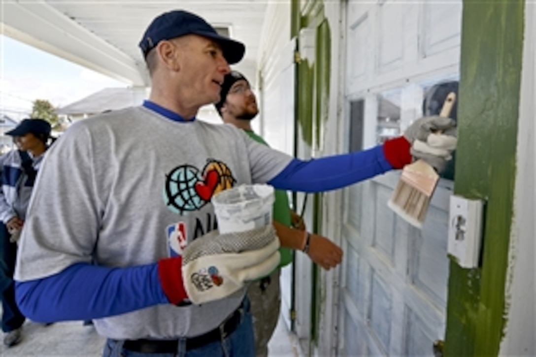 Marine Corps Sgt. Maj. Bryan B. Battaglia, senior enlisted advisor to the chairman of the Joint Chiefs of Staff, talks with a volunteer from Rebuilding Together before starting work on the home of a Vietnam War veteran in New Orleans, Feb. 14, 2014, as part of the seventh-annual NBA All-Star Day of Service. About 250 active-duty service members and veterans volunteered to work with past and present NBA players on six homes, including the homes of four veterans. 