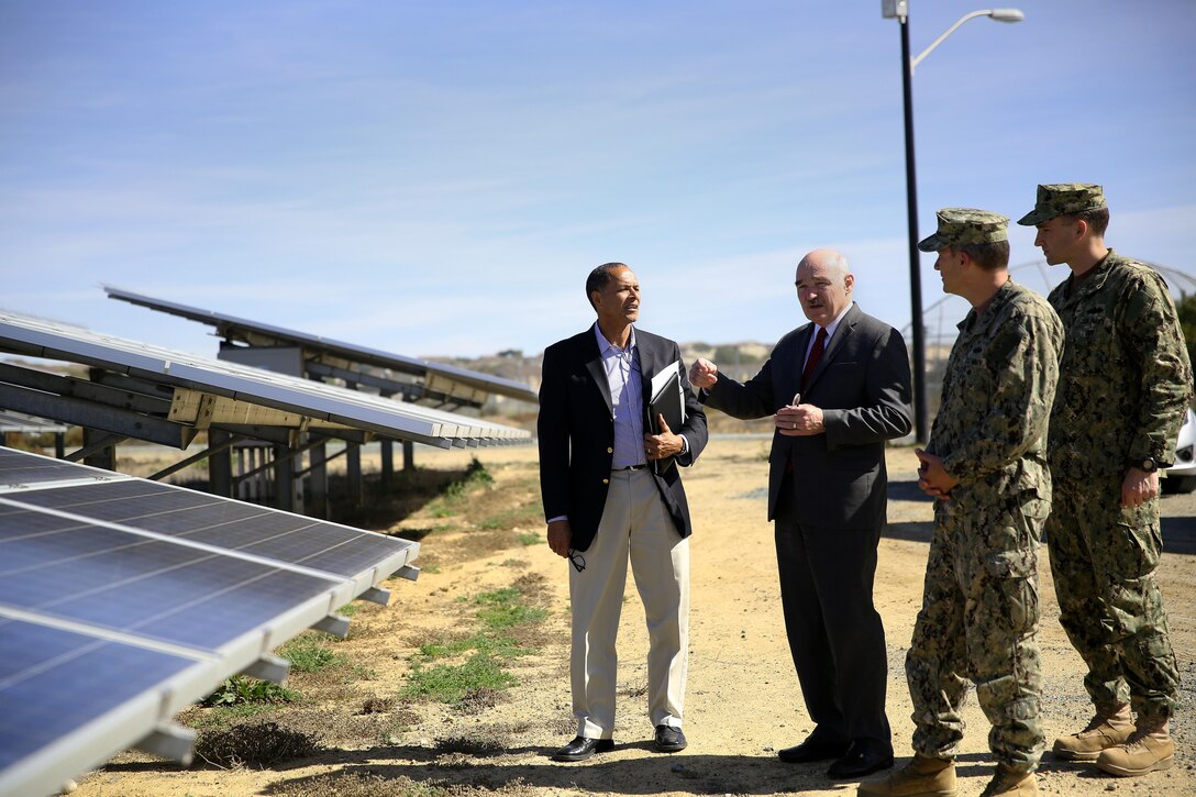 From left, Charles Howell, Dennis McGinn, Navy Capt. Charles R. Reuning and Lt. Cmdr Ben Wainwright talk about the Phase I and Phase II photovoltaic array (solar panels) at Box Canyon, near Wire Mountain housing. 

Assistant Secretary of the Navy-Energy, Installations and Environment, Dennis McGinn, visited Camp Pendleton to view the energy projects on base and to speak about energy goals for the future. “If nothing else, I want to leave you with an appreciation for how absolutely essential and inexplicably tied our mission readiness is to the kinds of energy we have and how we use it,” said McGinn.  

Howell is the resource efficiency manager for the base energy office.  Reuning is a facilities officer with Camp Pendleton. Wainwright is the Assistant Secretary of the Navy’s aide. 