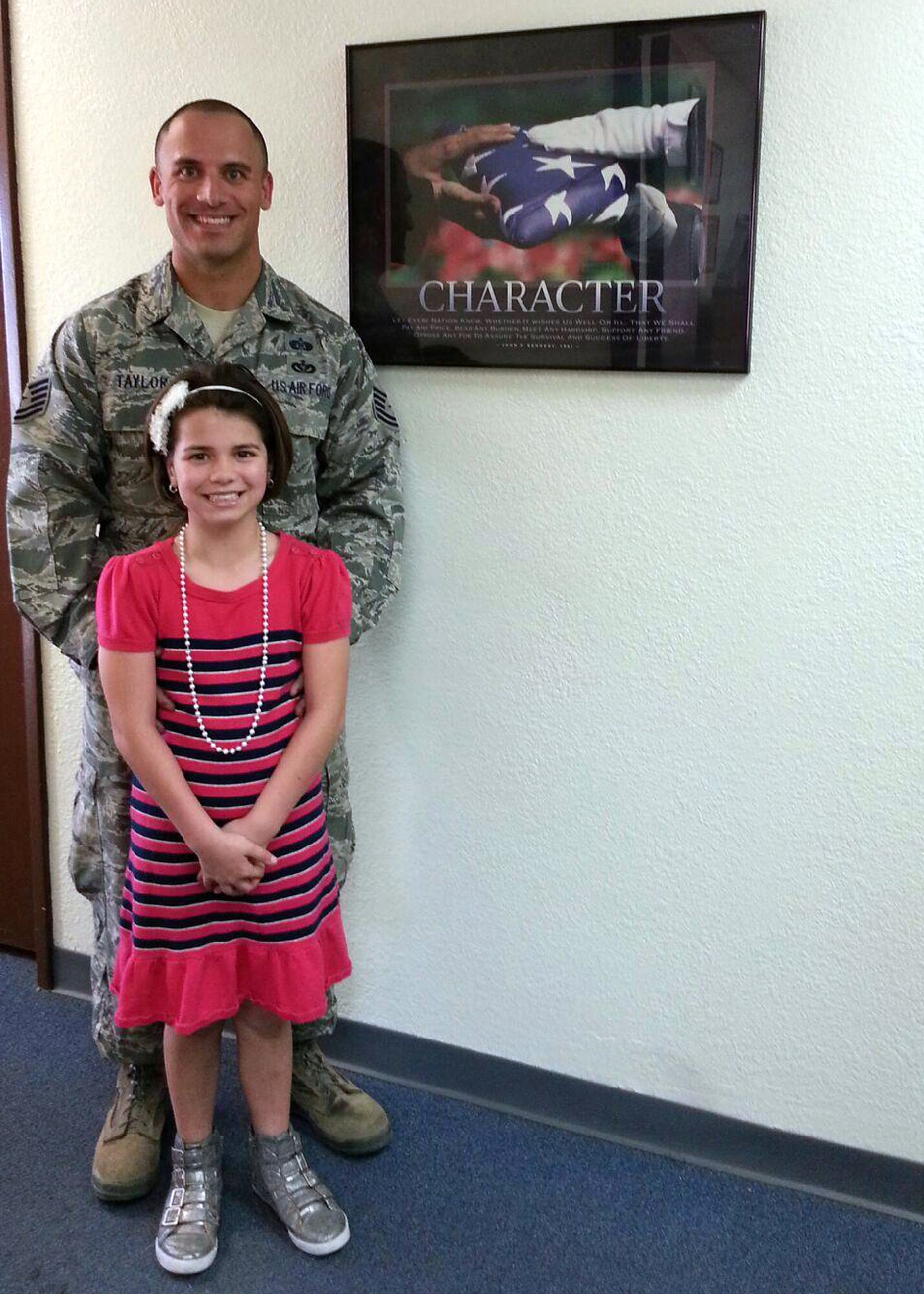 U.S. Air Force Tech. Sgt. Ryan Taylor, 355th Civil Engineering Squadron, noncommissioned officer in charge of the Readiness and Emergency Management Flight, and daughter Caylin, 8, semi-finalist for the Military Child of the Year Award, pose for a photo at Davis-Monthan Air Force Base, Ariz., Feb. 14, 2014. The MCOY Award is presented by Operation Homefront to outstanding military children who demonstrate resiliency, leadership and achievement. (Courtesy photo)