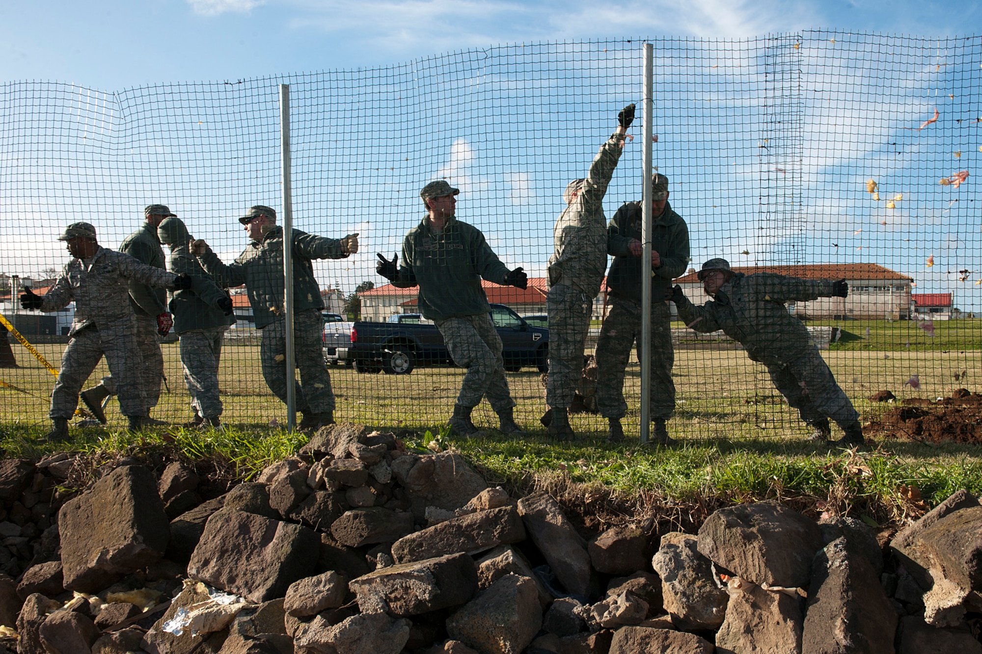 U.S. Air Force Airmen from the 65th Civil Engineer Squadron help to install a fence Feb. 15, 2014, at Lajes Field, Azores. Lajes Field was hit with a low pressure weather system Feb. 13, and strong winds caused damages to base facilities and military family housing. (U.S. Air Force photo by Tech. Sgt. Paul Villanueva II/Released)