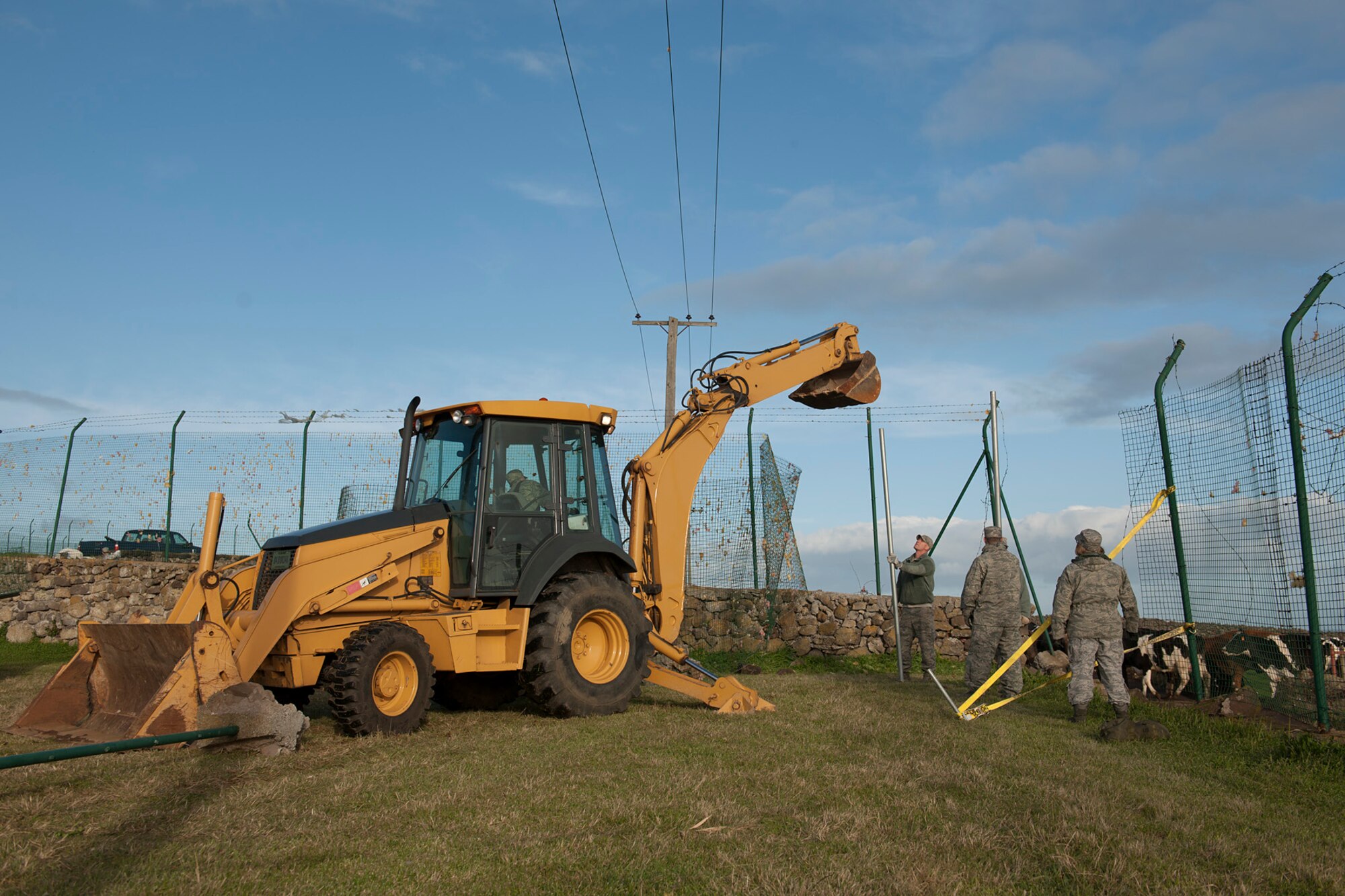 U.S. Air Force Airmen from the 65th Civil Engineer Squadron help to install a fence Feb. 15, 2014, at Lajes Field, Azores. Lajes Field was hit with a low pressure weather system Feb. 13, and strong winds caused damages to base facilities and military family housing. (U.S. Air Force photo by Tech. Sgt. Paul Villanueva II/Released)