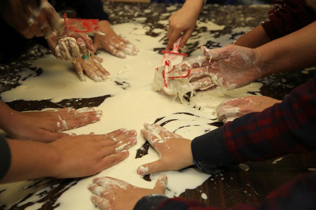 Students from Condor Elementary School get hands-on at the Obleck Station during Condor Elementary's Science Night, Feb. 5, 2014. The station taught children about the effects of pressure on certain substances.


