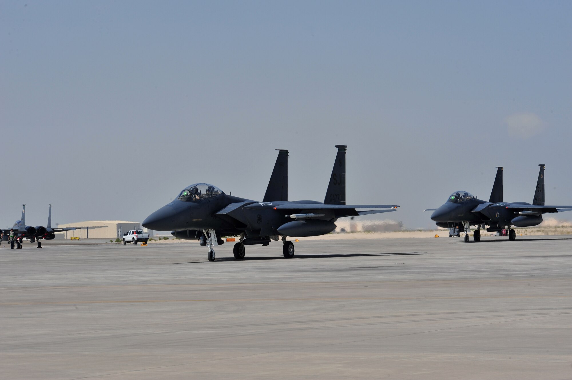 Two F-15E fighter aircraft assigned to the 335th Expeditionary Fighter Squadron taxi out on the flightline to launch during an exercise at an undisclosed location in Southwest Asia, Feb. 14, 2014. (U.S. Air Force photo by Staff Sgt. Michael Means/Released)