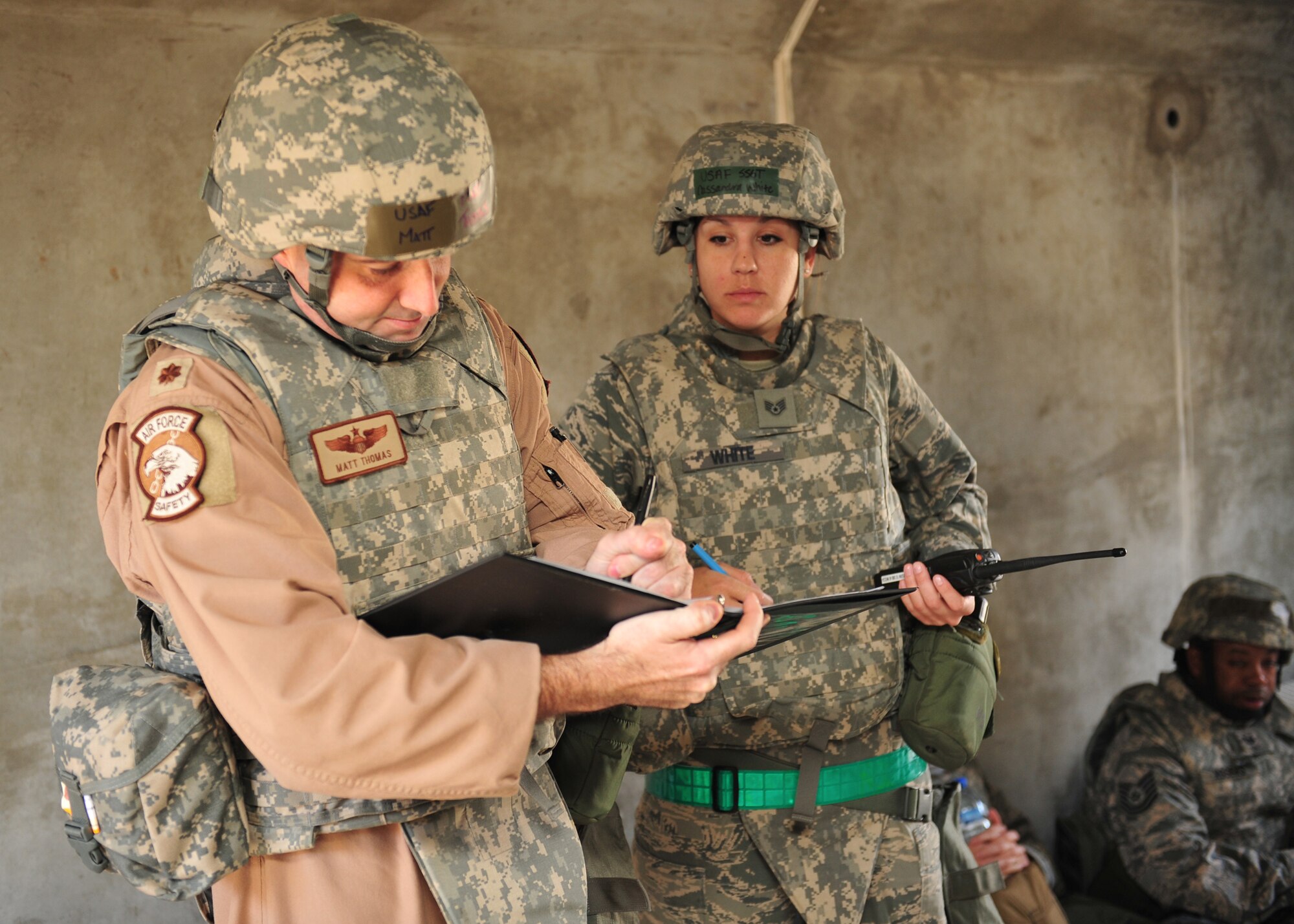 Air Force Maj. Matthew Thomas, 380th Air Expeditionary Wing deputy chief of safety and bunker commander, and Air Force Staff Sgt. Cassandra White, executive assistant for the 380 AEW command chief, go over the bunker checklist after taking cover during a wing exercise here today. (U.S. Air Force photo by Staff Sgt. Michael Means/Released)