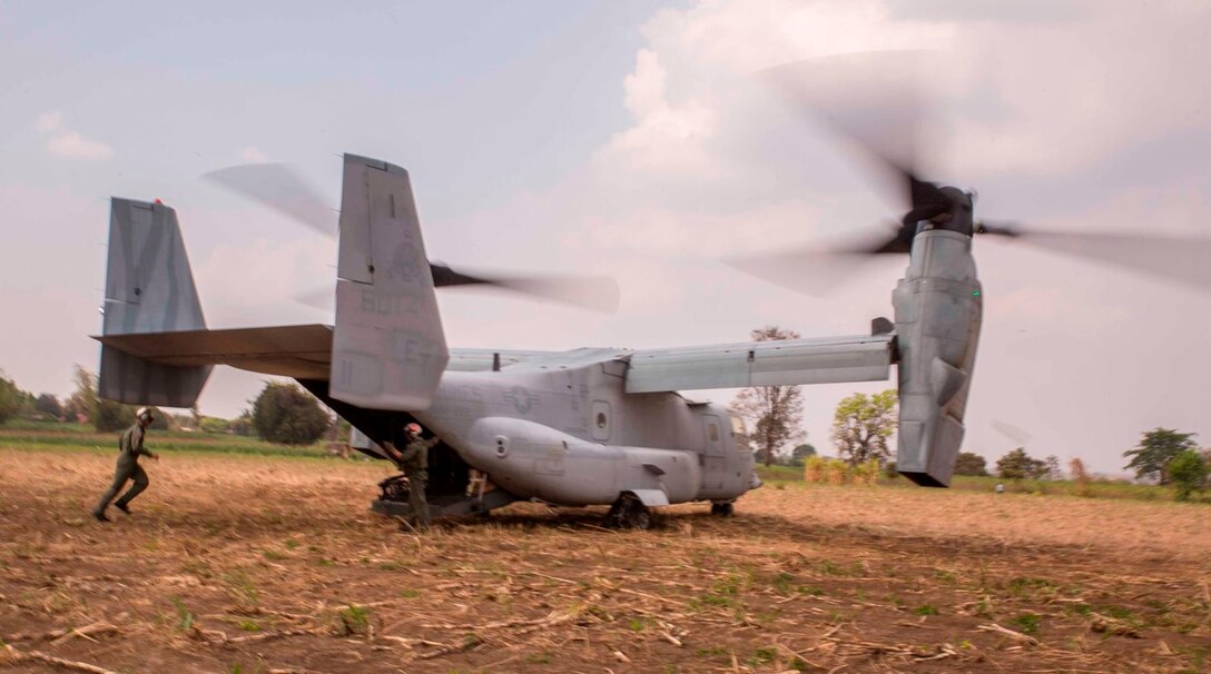 Royal Thai Air Force Flying Officer Satapat Rattana, runs into an MV-22B Osprey during a tactical recovery of aircraft and personnel drill Feb. 13 during Exercise Cobra Gold 2014. CG 14 is a joint, multinational exercise conducted annually in the Kingdom of Thailand aimed at enhancing and increasing combined interoperability. Rattana is a pilot with Squadron 403, Wing 4, Royal Thai Air Force. The MV-22B Osprey is with Marine Medium Tiltrotor Squadron 262, Marine Aircraft Group 36, 1st Marine Aircraft Wing, III Marine Expeditionary Force. (U.S. Marine Corps photo by Cpl. James R. Smith/released)