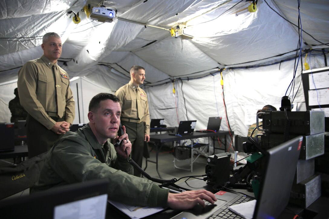 Major O.J. Weiss (lower left), the operations officer for Marine Aircraft Group 31, demonstrates the effectiveness of the communication system at a remote site to Lt. Col. Nicholas Neimer (left), commanding officer of MAG-31 Headquarters squadron, and Lt. Col. Joseph Reedy (right), the executive officer of MAG-31 Headquarters Squadron, during MAG-31's Command Post Exercise (CPX) aboard Marine Corps Air Station Beaufort, Feb. 7. The exercise was executed concurrent with Marine Division Tactics Course in order to test the capabilities of the group to conduct aviation operations from expeditionary sites and exercise tactical command and control. The ability to operate expeditiously promotes MAG-31's ability to act as the Aviation Command Element (ACE) of a Marine Air-Ground Task Force.